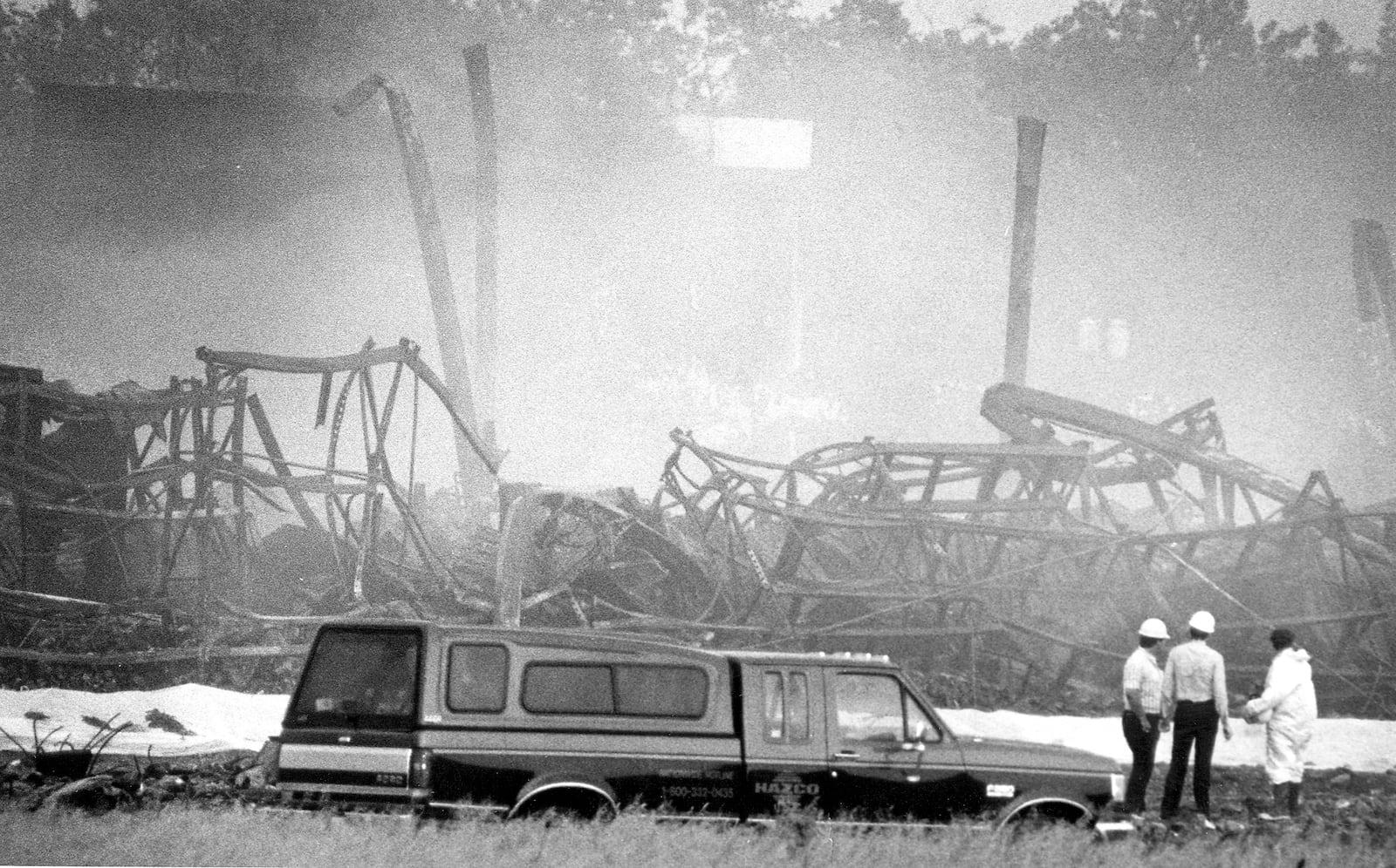 Officials inspect the remains of the Sherwin-Williams warehouse fire that burned in May 1987. File photo