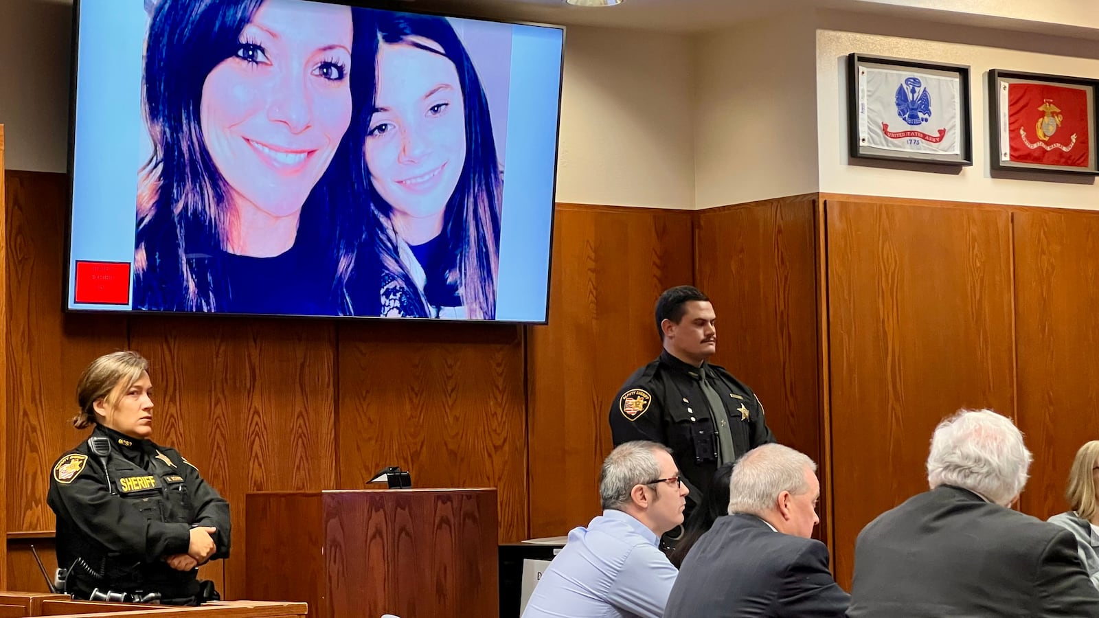 Stephen Marlow sits at left with his attorneys on Dec. 30, 2024, as a photo of homicide victims Sarah and Kayla Anderson is shown on a TV screen in Montgomery County Common Pleas Court. AIMEE HANCOCK/STAFF