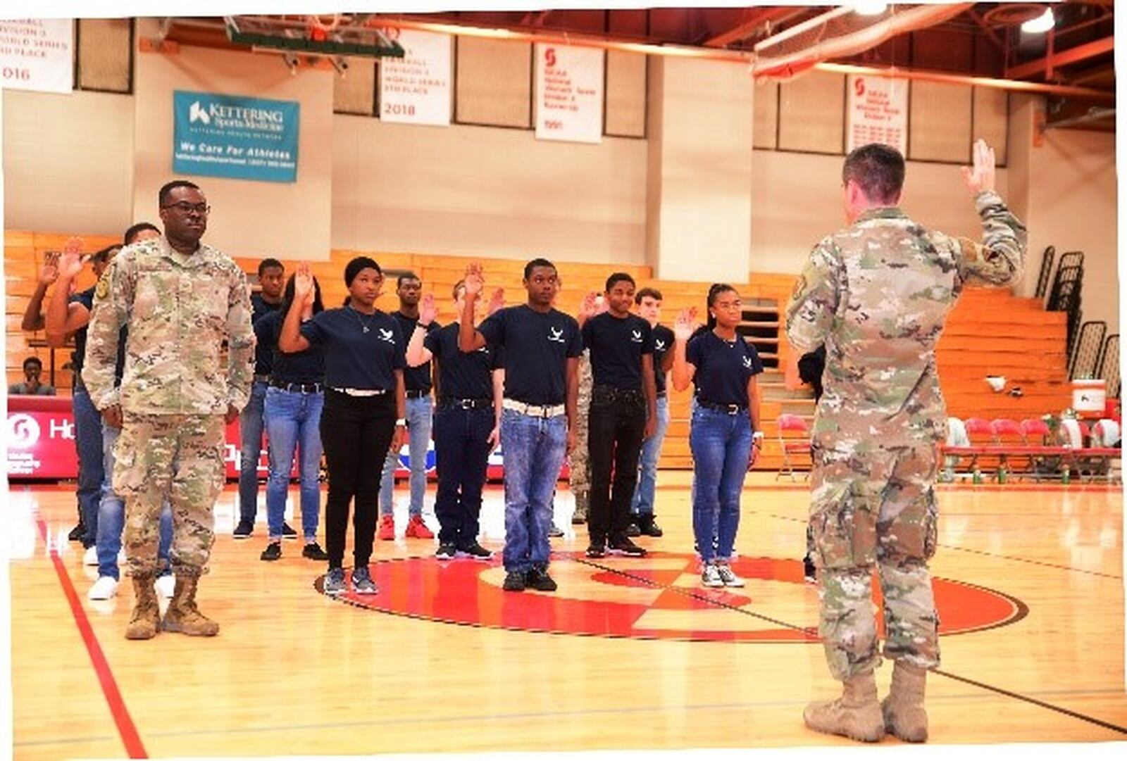 Colonel Paul Burger, Commander off 88th Mission Support Group at Wright Patterson Air Force Base, conducts swearing in ceremony of 16 enlistees at halftime of Sinclair ‘s Military Appreciation Night basketball game on Veterans Day. Eric Deeters/Sinclair Community College)