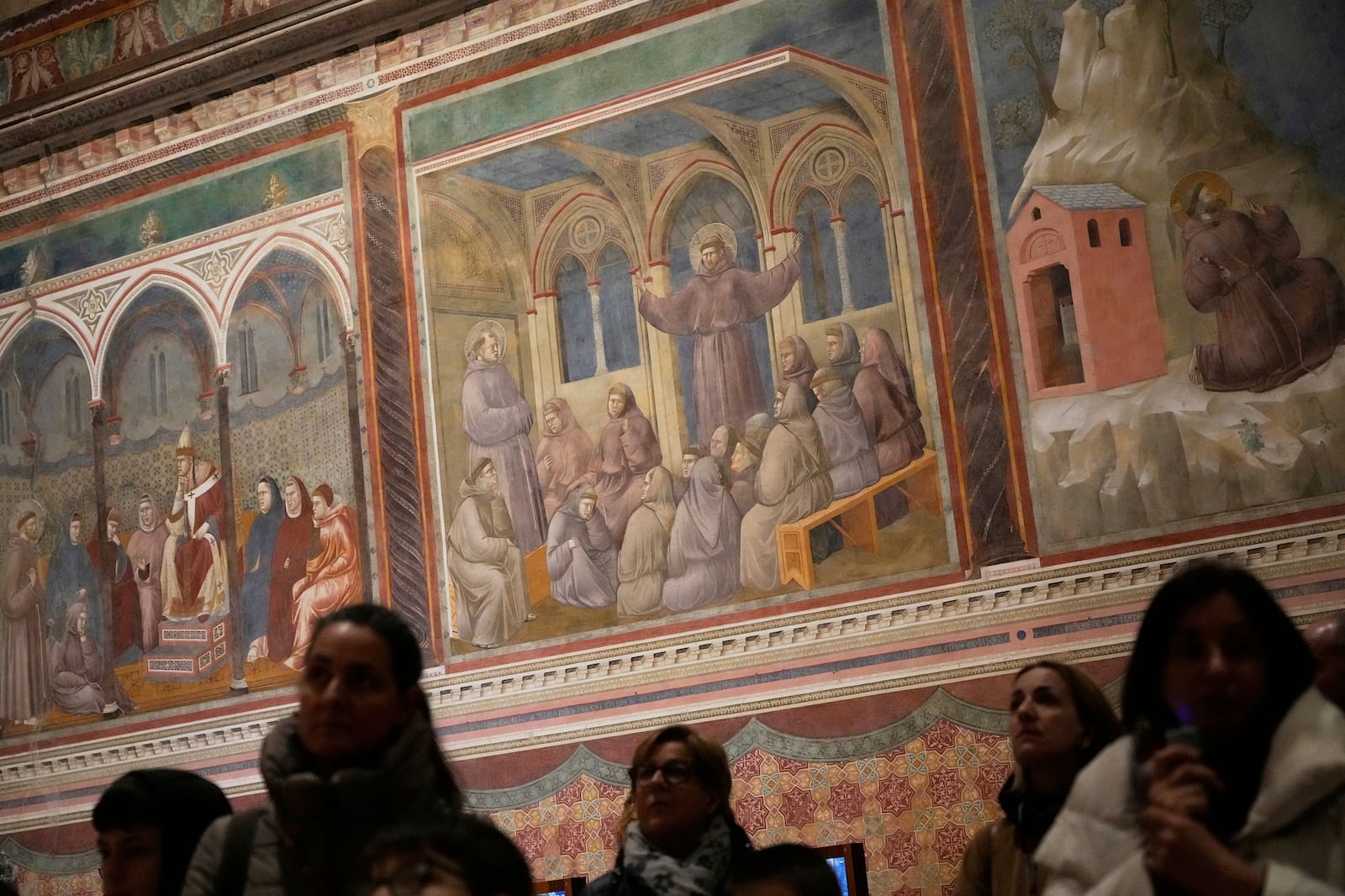 Visitors look at Giotto's frescoes inside St. Francis Basilica in Assisi, Italy, Saturday, March 1, 2025. (AP Photo/Gregorio Borgia)