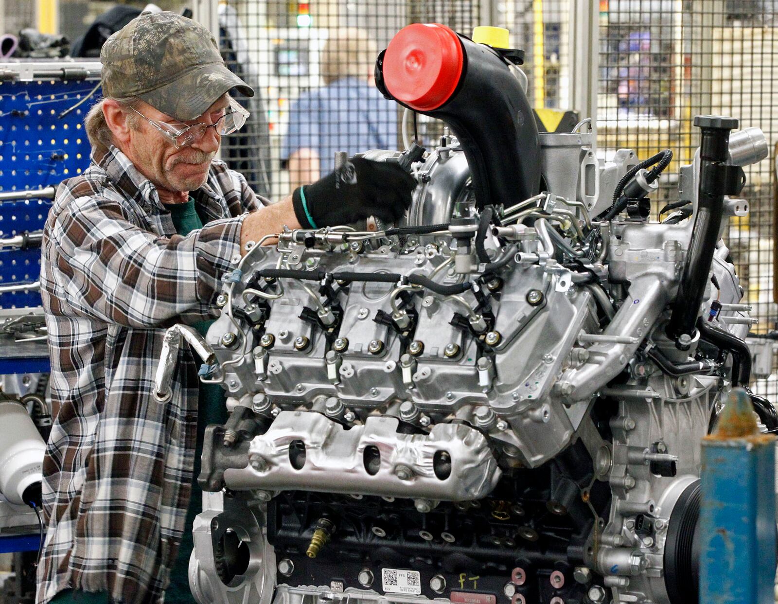 DMAX worker Gary Gillman works on a 6.6 liter Duramax Diesel engine at the company’s Moraine plant. STAFF FILE PHOTO / TY GREENLEES