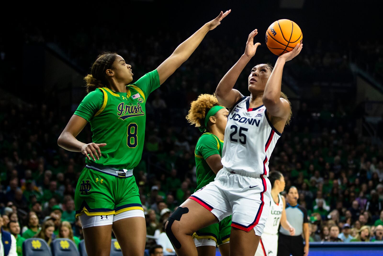 UConn forward Ice Brady (25) drives to the basket as Notre Dame guard Cassandre Prosper (8) defends during the first half of an NCAA college basketball game Thursday, Dec. 12, 2024, in South Bend, Ind. (AP Photo/Michael Caterina)