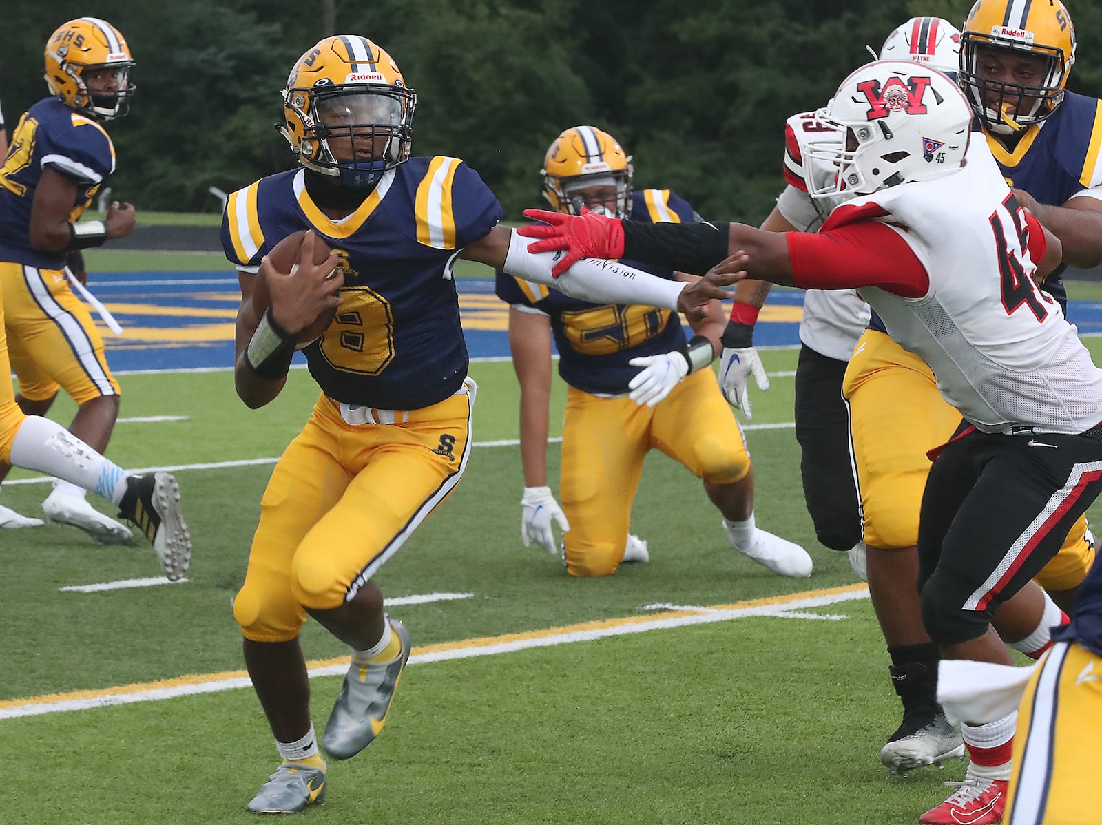 Springfield quarterback Te'Sean Smoot avoids a tackle by Wayne's Jaylen Lovett. BILL LACKEY/STAFF