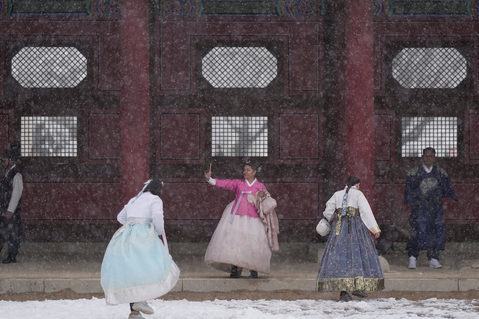 Visitors walk in snow at the Gyeongbok Palace, one of South Korea's well-known landmarks, in Seoul, South Korea, Wednesday, Nov. 27, 2024. (AP Photo/Lee Jin-man)