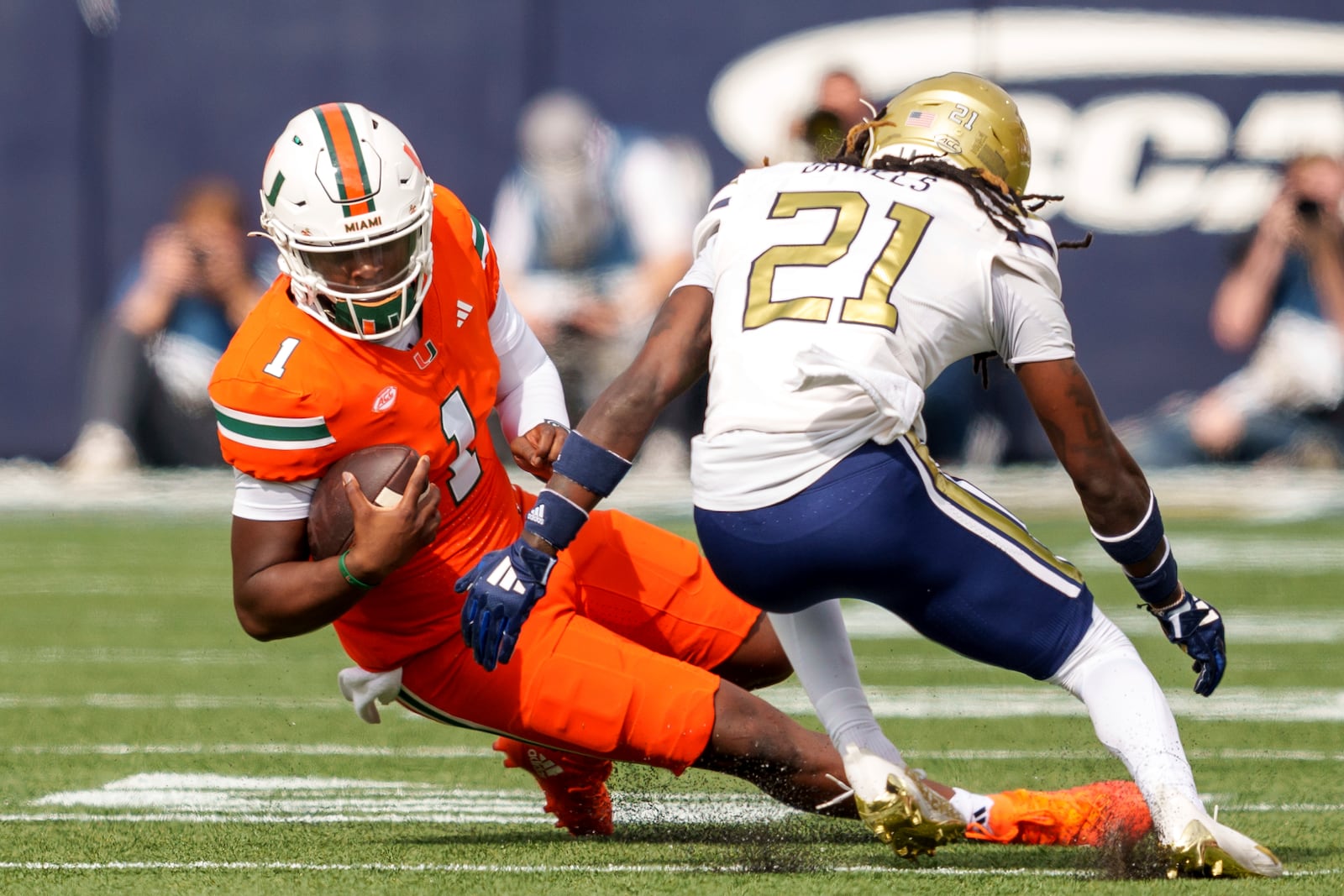 Miami quarterback Cam Ward (1) slides before being tackled by Georgia Tech defensive back Omar Daniels (21) during the first half of an NCAA college football game, Saturday, Nov. 9, 2024, in Atlanta. (AP Photo/Jason Allen)