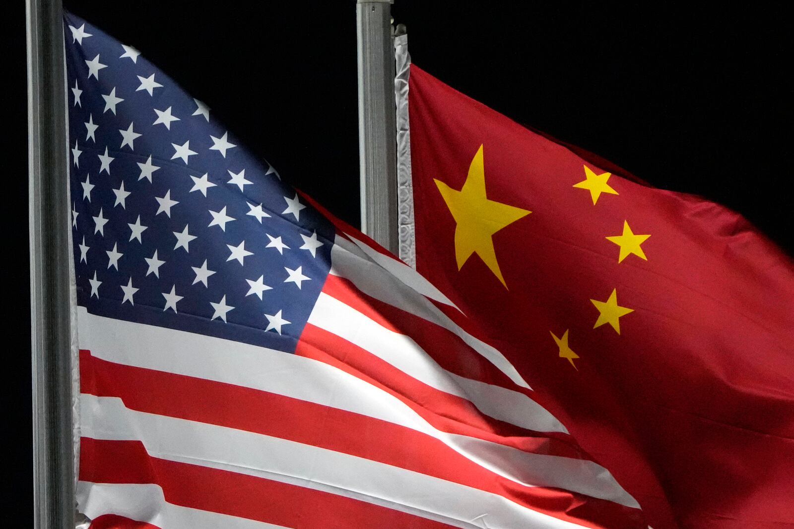 FILE - The American and Chinese flags displayed at Genting Snow Park ahead of the 2022 Winter Olympics, Feb. 2, 2022, in Zhangjiakou, China. (AP Photo/Kiichiro Sato, File)