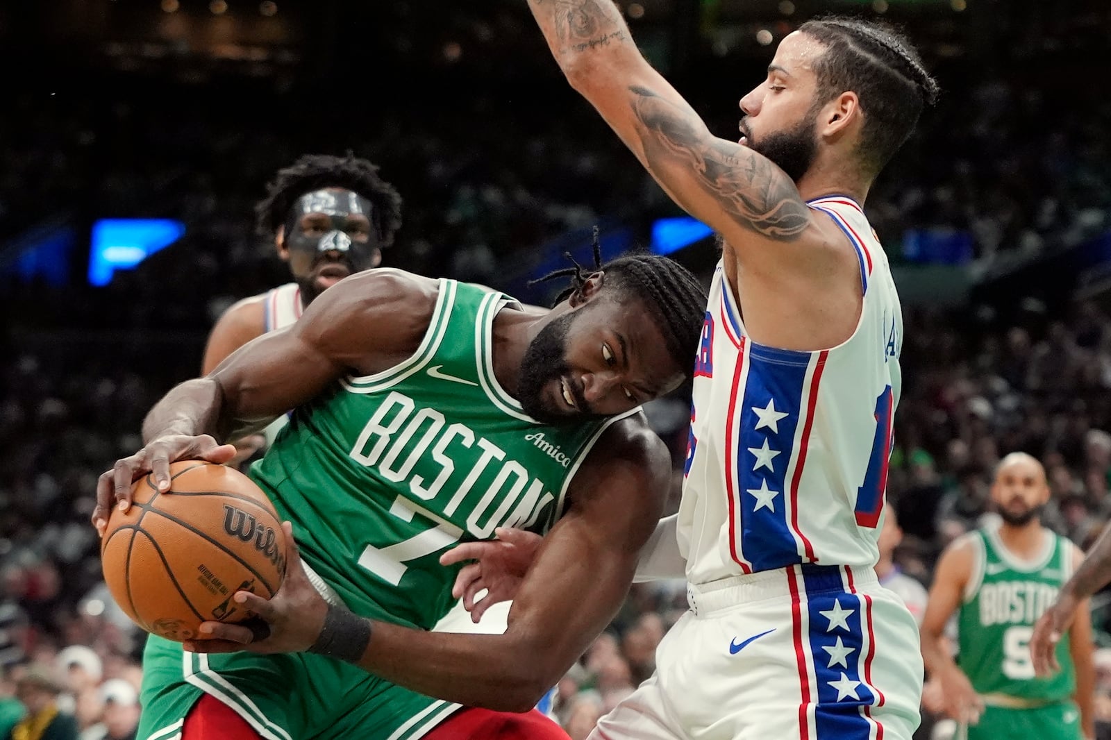 Boston Celtics' Jaylen Brown (7) drives against Philadelphia 76ers' Caleb Martin during the first half of an NBA basketball game, Wednesday, Dec. 25, 2024, in Boston (AP Photo/Michael Dwyer)