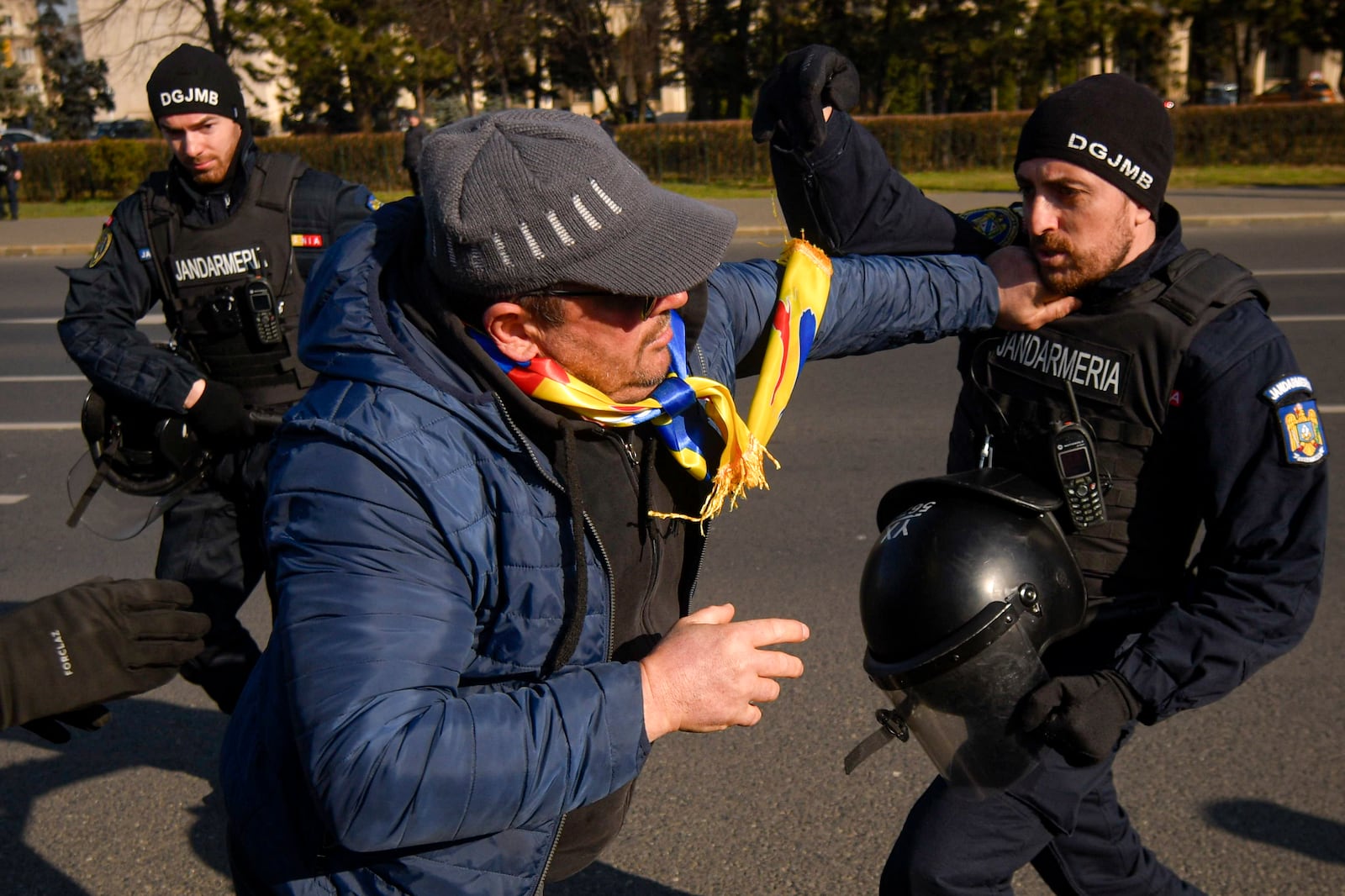 Riot police scuffle with supporters of Calin Georgescu, the winner of Romania's first round of presidential election which the Constitutional Court later annulled, who broke through police lines in front of the government headquarters, in Bucharest, Romania, Monday, Feb. 10, 2025. (AP Photo/Alexandru Dobre)