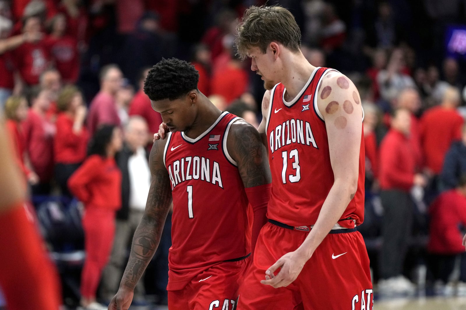 Arizona guard Caleb Love (1) and Henri Veesaar walk off the court after losing to BYU during an NCAA college basketball game, Saturday, Feb. 22, 2025, in Tucson, Ariz. (AP Photo/Rick Scuteri)