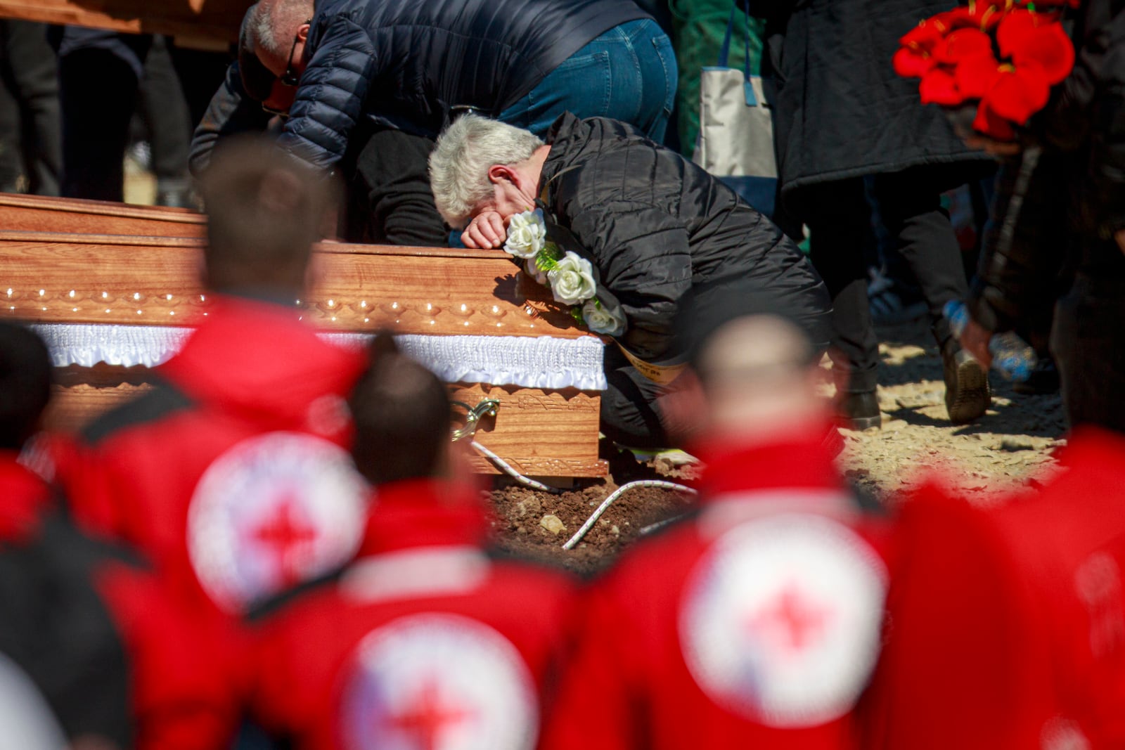 A person cries leaning on a coffin during the funeral ceremony of the victims of a massive nightclub fire in the town of Kocani, North Macedonia, Thursday, March 20, 2025. (AP Photo/Visar Kryeziu)