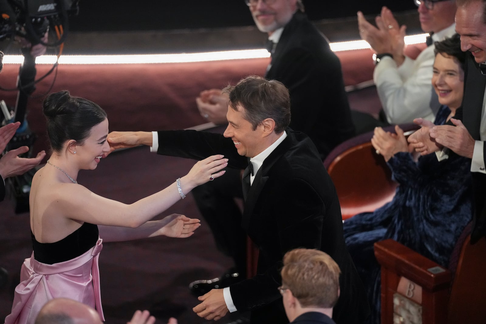 Mikey Madison, left, embraces Sean Baker after he wins the award for best original screenplay for "Anora" during the Oscars on Sunday, March 2, 2025, at the Dolby Theatre in Los Angeles. (AP Photo/Chris Pizzello)