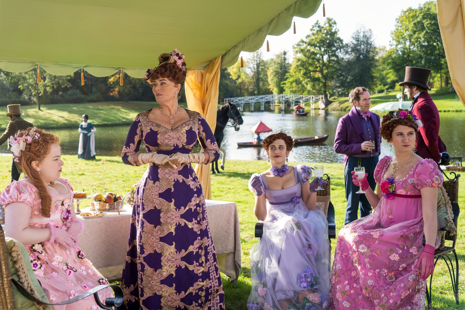 This image released by Netflix shows Nicola Coughlan, from left, Polly Walker, Harriet Cains and Bessie Carter in a scene from "Bridgerton." Television producers Shonda Rhimes and Betsy Beers will be honored for their wardrobe efforts on projects like "Grey's Anatomy" and "Bridgerton" at the Costume Designers Guild Awards. (Liam Daniel/Netflix via AP)