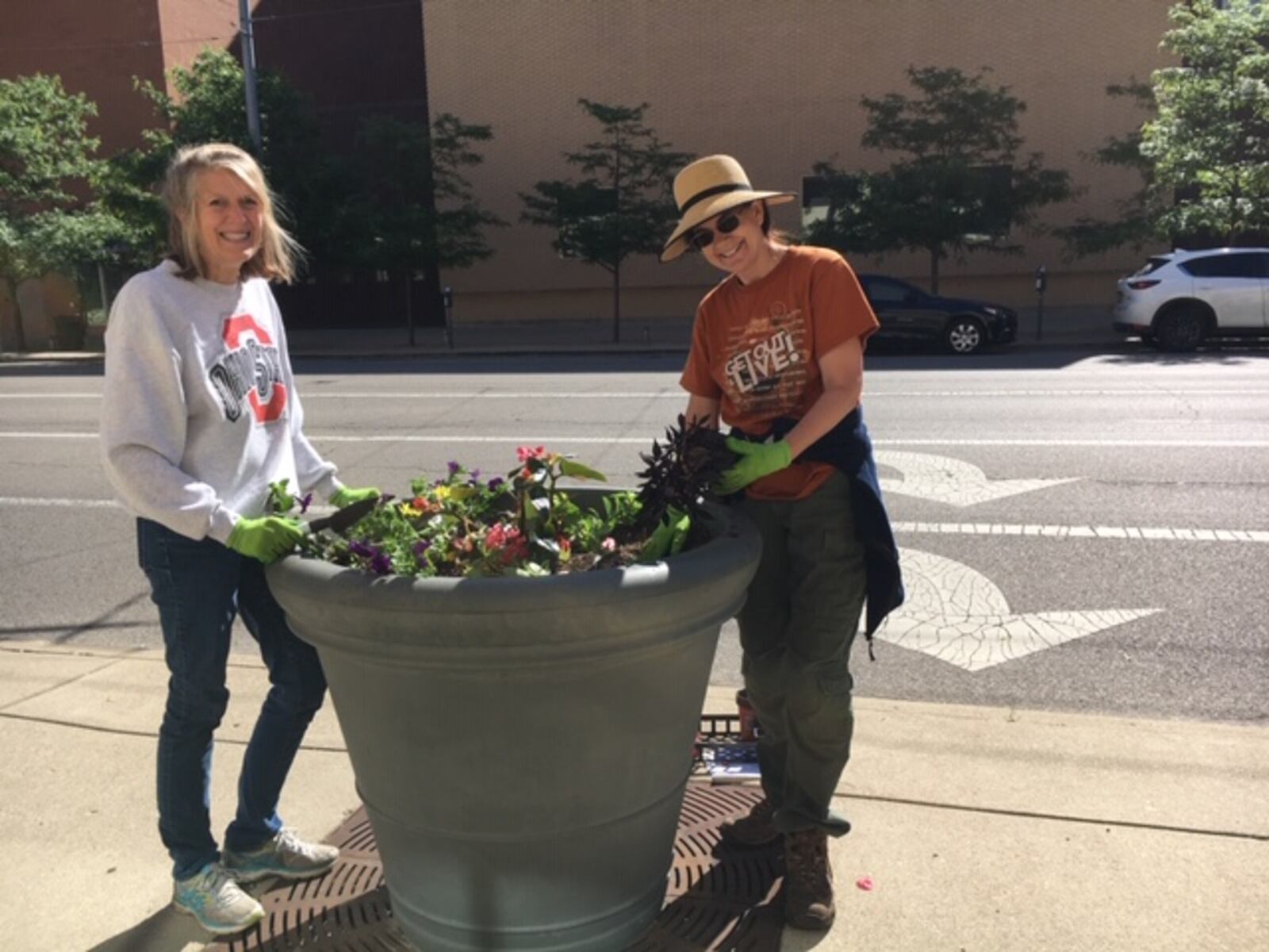 Volunteers work on sidewalk planters on North Ludlow Street Monday morning. 