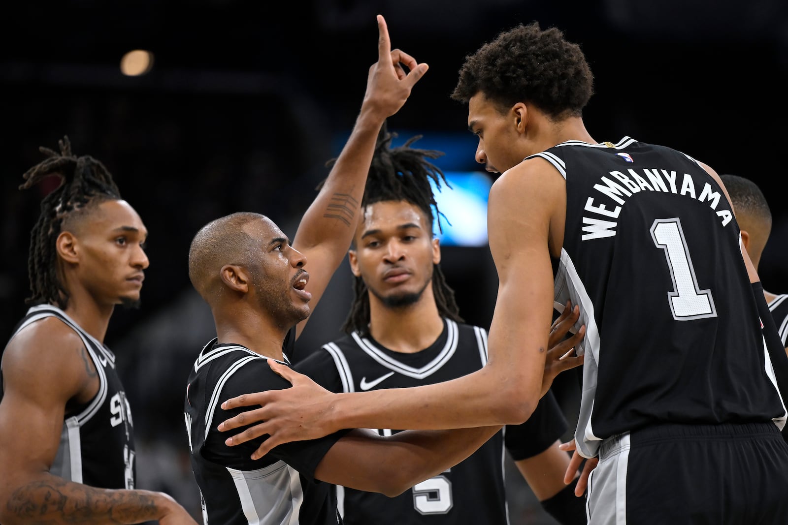 San Antonio Spurs guard Chris Paul, second from left, speaks with Spurs forward Victor Wembanyama (1) during the second half of their NBA basketball game against the Washington Wizards, Wednesday, Nov. 13, 2024, in San Antonio. San Antonio won 139-130. (AP Photo/Darren Abate)