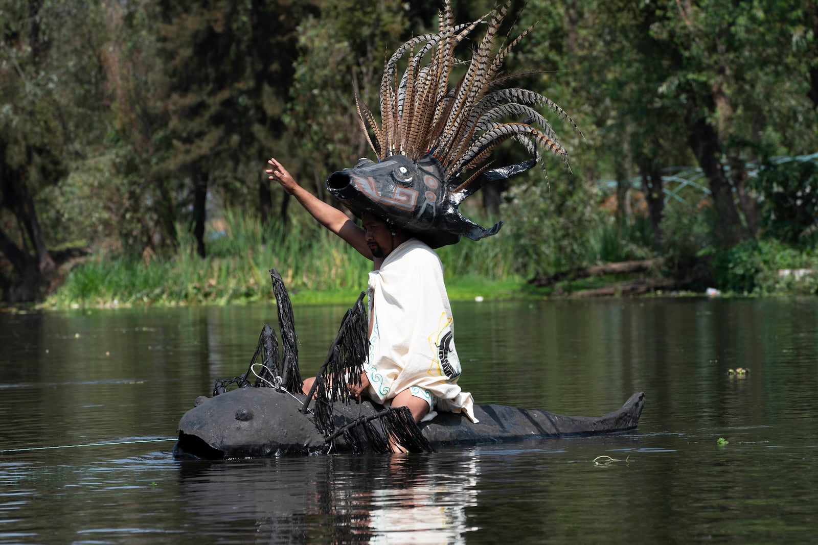 FILE - Manuel Rodriguez sits atop a canoe shaped like an axolotl during its symbolic release in the canals of Xochimilco, a borough of Mexico City, Feb. 16, 2022. (AP Photo/Marco Ugarte, File)