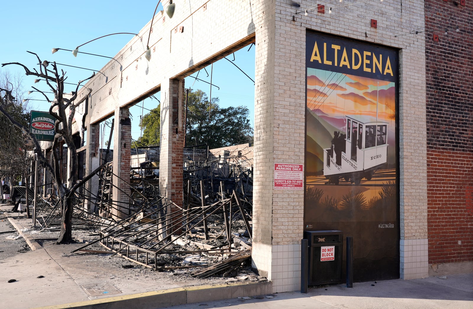 A wall mural depicting Altadena stands next to the destroyed Altadena Hardware store after the Eaton Fire, Tuesday, Jan. 14, 2025, in Altadena, Calif. (AP Photo/Chris Pizzello)