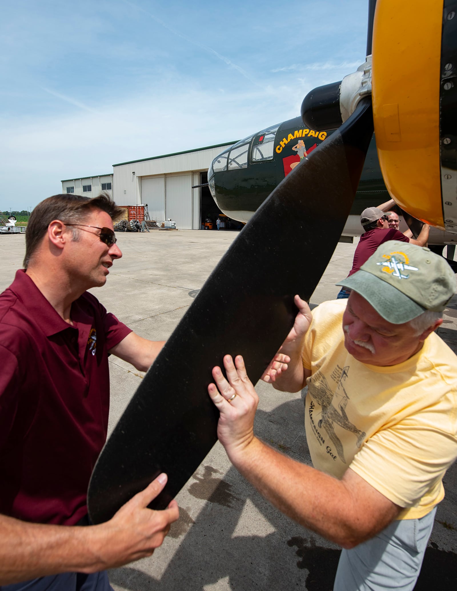 Dave Shiffer (left), Champaign Aviation Museum executive director and head of flight operations, and volunteer Matt Davis help cycle a prop on the World War II B-25 bomber Champaign Gal while preparing to start the engine July 15 outside the museum at Grimes Field in Urbana. U.S. AIR FORCE PHOTO/R.J. ORIEZ