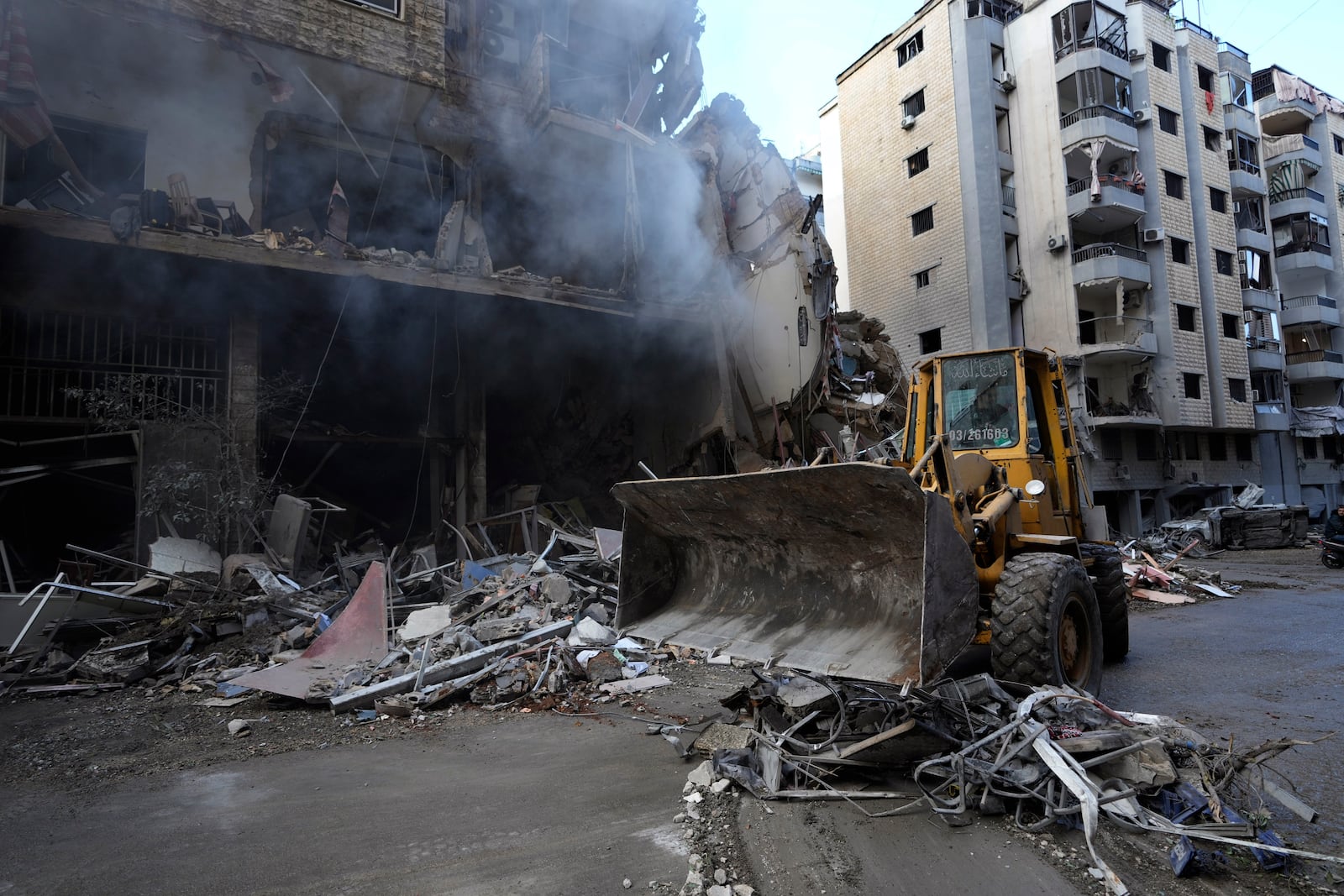 A bulldozer removes the rubble in front of a destroyed building that was hit Sunday night in an Israeli airstrike in Dahiyeh, in the southern suburb of Beirut, Lebanon, Monday, Nov. 25, 2024. (AP Photo/Hussein Malla)