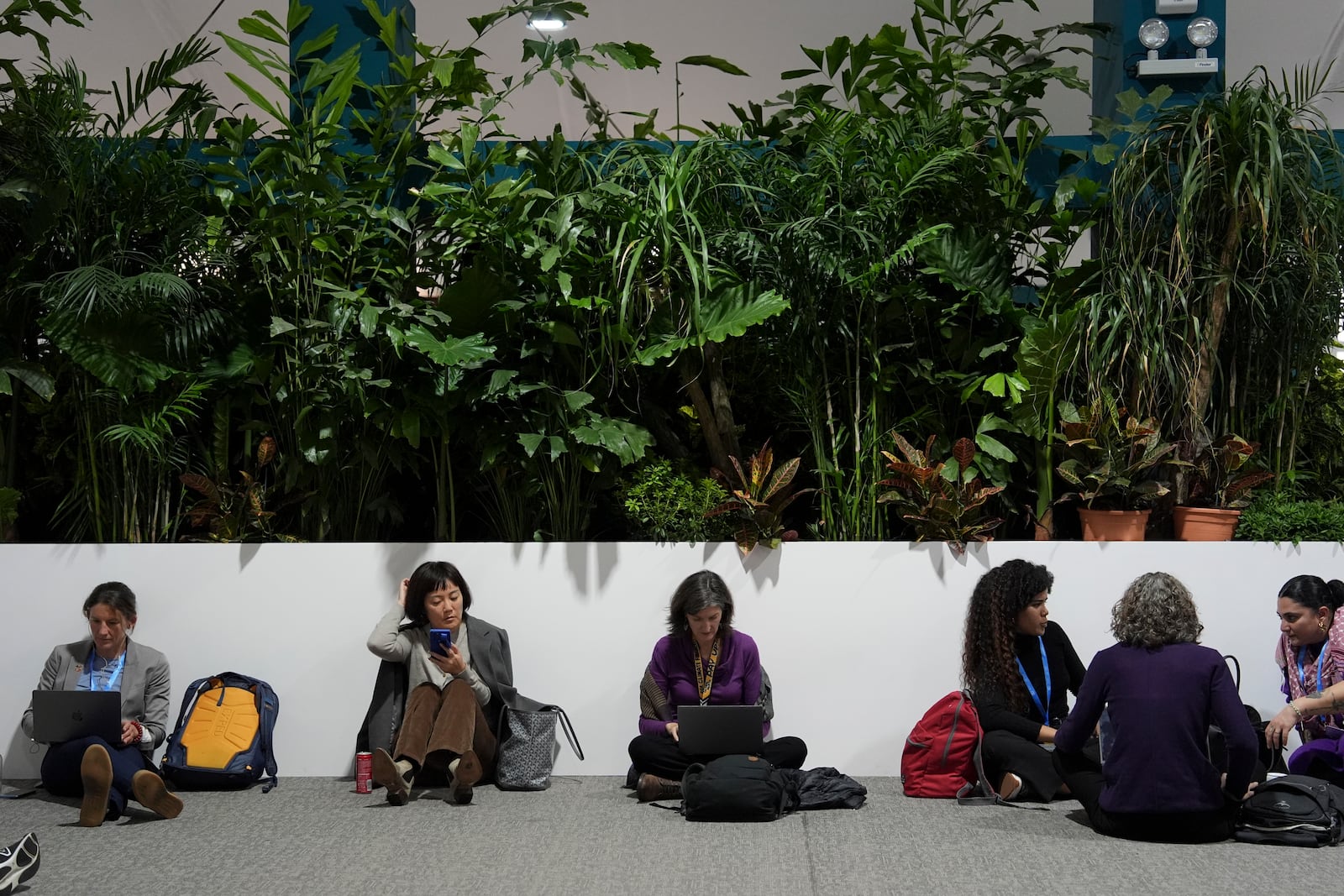 Attendees sit during a break while at the COP29 U.N. Climate Summit, Monday, Nov. 18, 2024, in Baku, Azerbaijan. (AP Photo/Joshua A. Bickel)