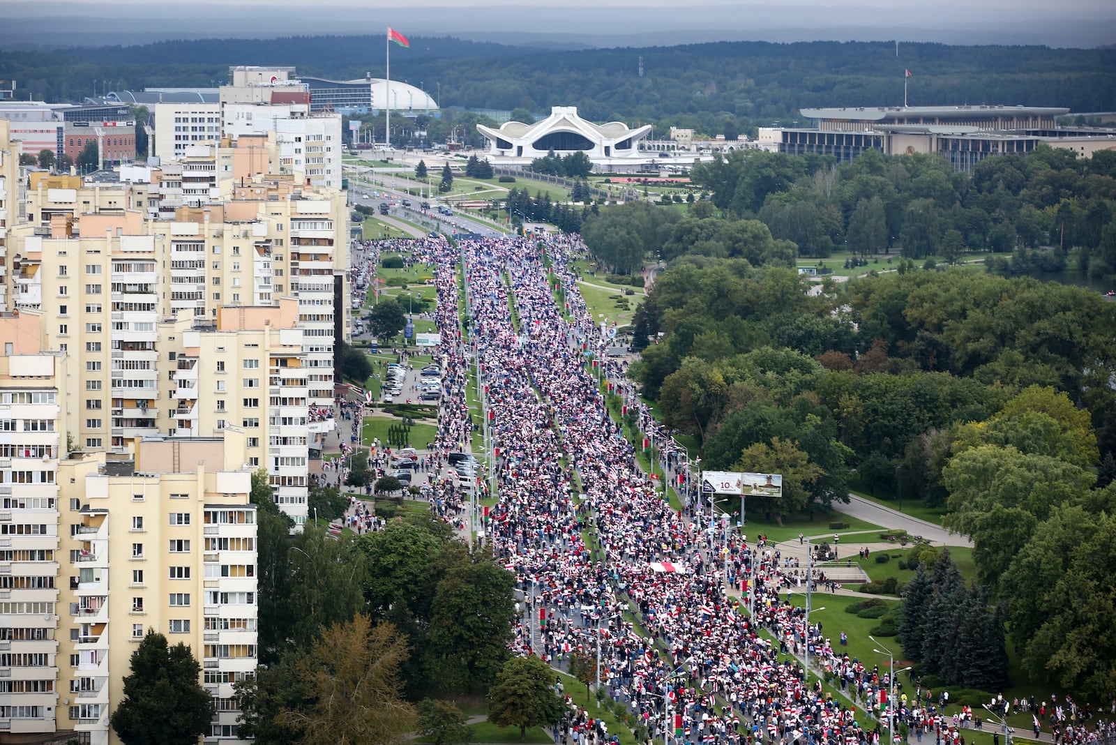 FILE - Belarusian opposition supporters carry old Belarusian national flags, which became symbols of anti-government protests, as they walk near the residence of Belarusian President Alexander Lukashenko in Minsk, Belarus, Sept. 6, 2020. (AP Photo, File)