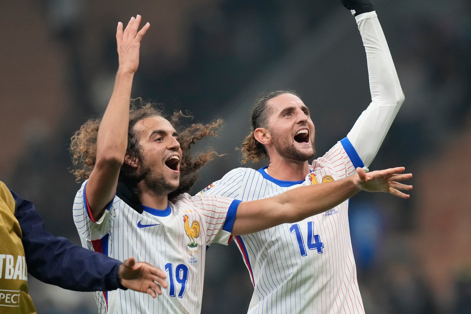 France's Adrien Rabiot, right, celebrates with Matteo Guendouzi after the Nations League soccer match between Italy and France, at the San Siro stadium in Milan, Italy, Sunday, Nov. 17, 2024. (AP Photo/Luca Bruno)