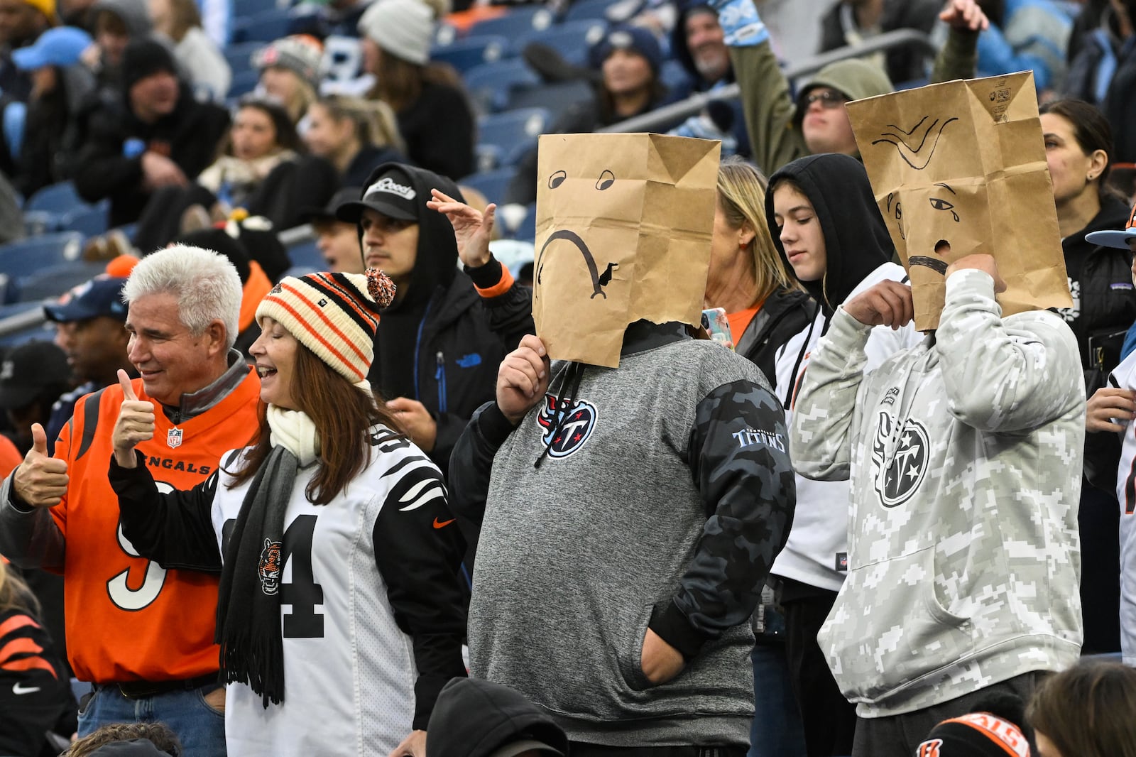 Tennessee Titans fans react next to Cincinnati Bengals fans, at left, in the fourth quarter of an NFL football game Sunday, Dec. 15, 2024, in Nashville, Tenn. (AP Photo/John Amis)