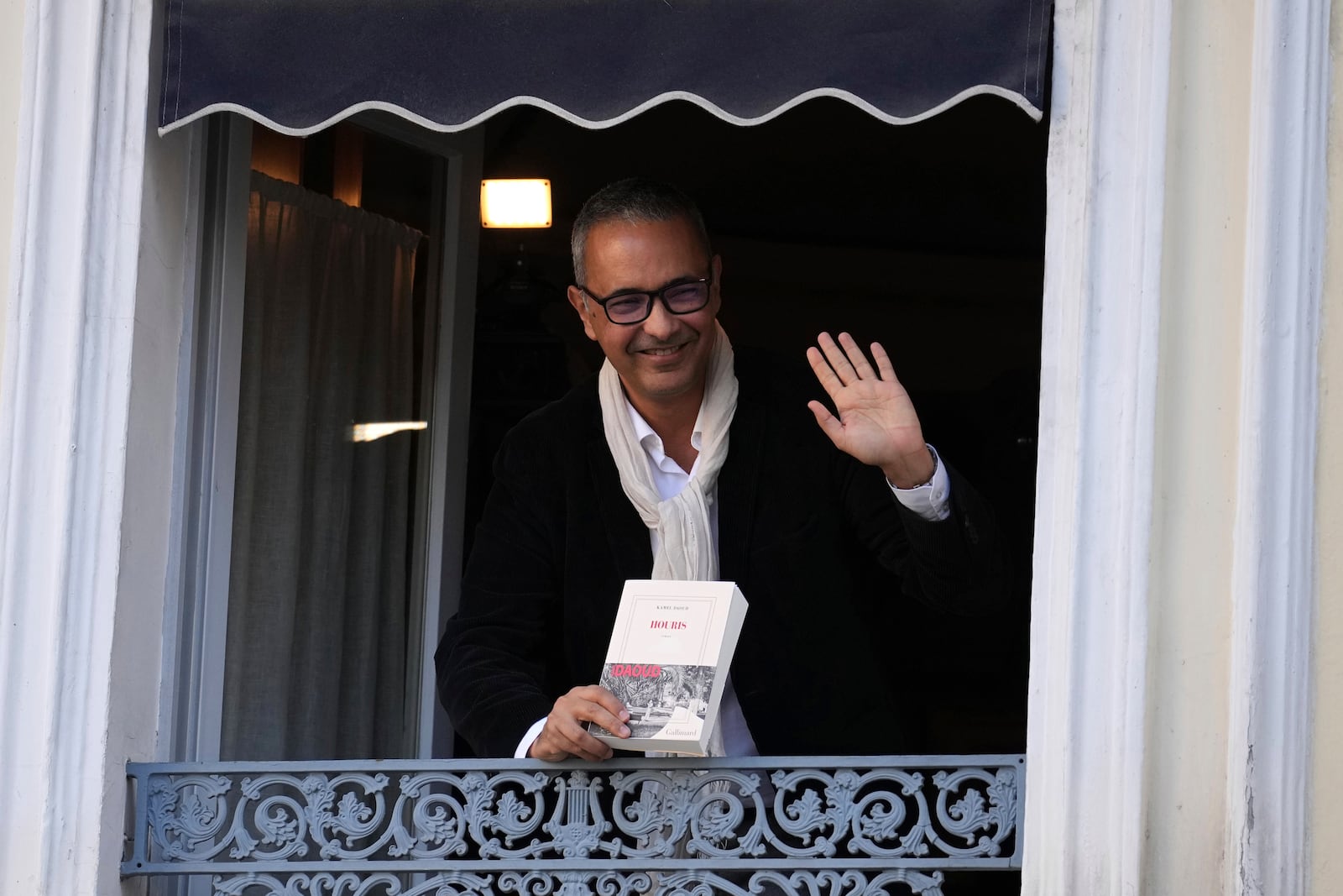 Algerian-French novelist Kamel Daoud holds his book Houris after being awarded with the Goncourt, France's most prestigious literary prize, Monday, Nov. 4, 2024 in Paris. (AP Photo/Aurelien Morissard)