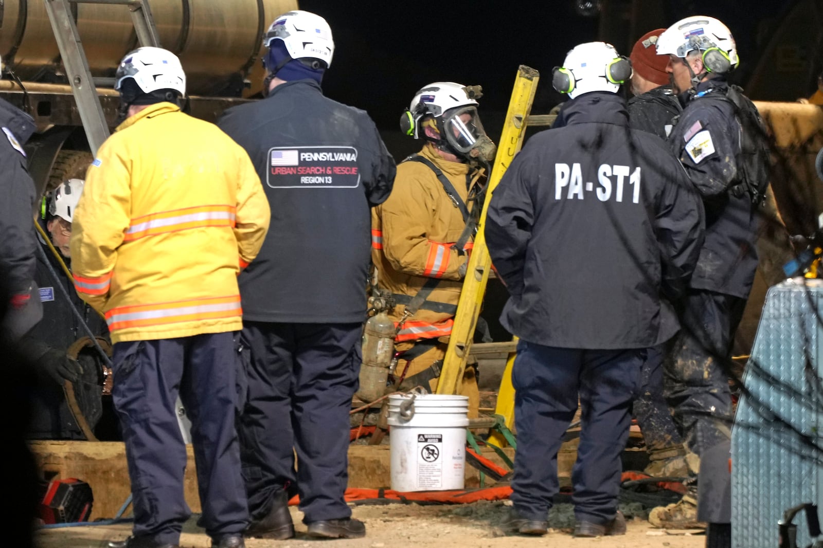 Rescue workers search through the night in a sinkhole for Elizabeth Pollard, who disappeared while looking for her cat, in Marguerite, Pa., Tuesday, Dec. 3, 2024. (AP Photo/Gene J. Puskar)