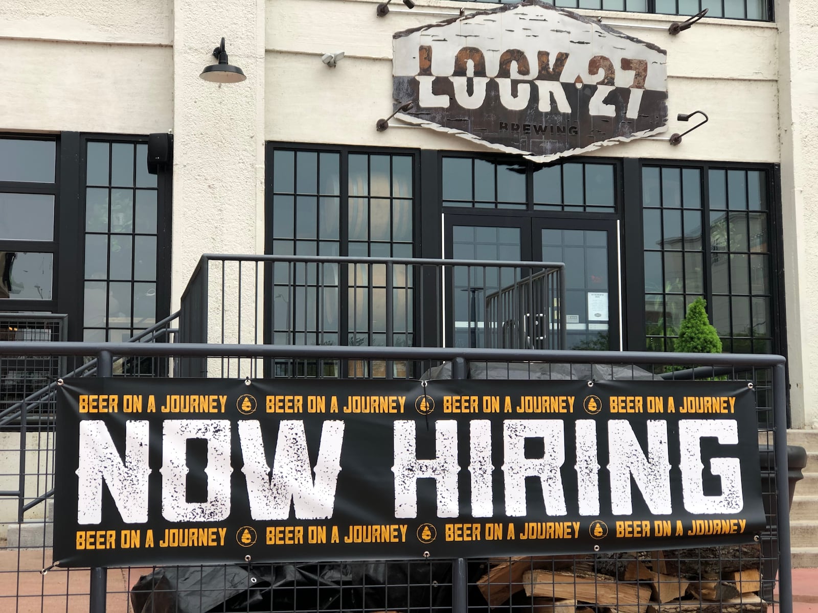 A "now hiring" sign outside of Lock 27 Brewing in downtown Dayton. Lock 27 has several job openings posted on its website. CORNELIUS FROLIK / STAFF