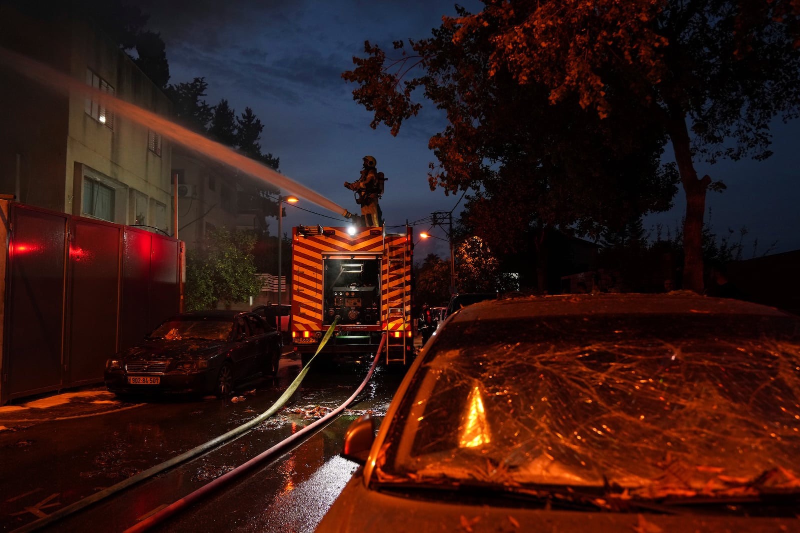 Firefighters work to extinguish a fire after a rocket fired from Lebanon hit Kiryat Ata, northern Israel, on Monday, Nov. 11, 2024. (AP Photo/Francisco Seco)