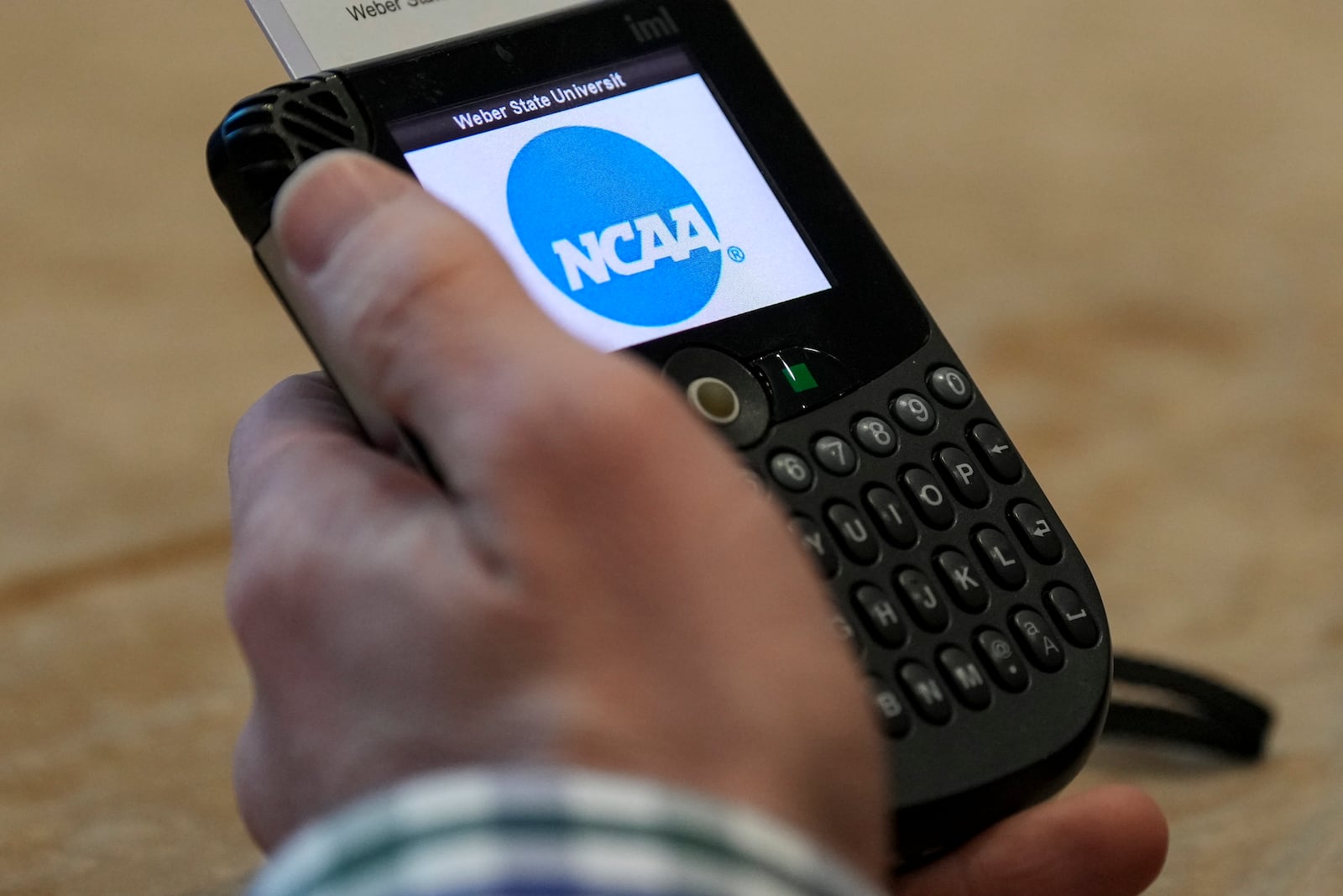 An NCAA delegate holds a voting machine during the organizations Division I Business Session at their annual convention Wednesday, Jan. 15, 2025, in Nashville, Tenn. (AP Photo/George Walker IV)