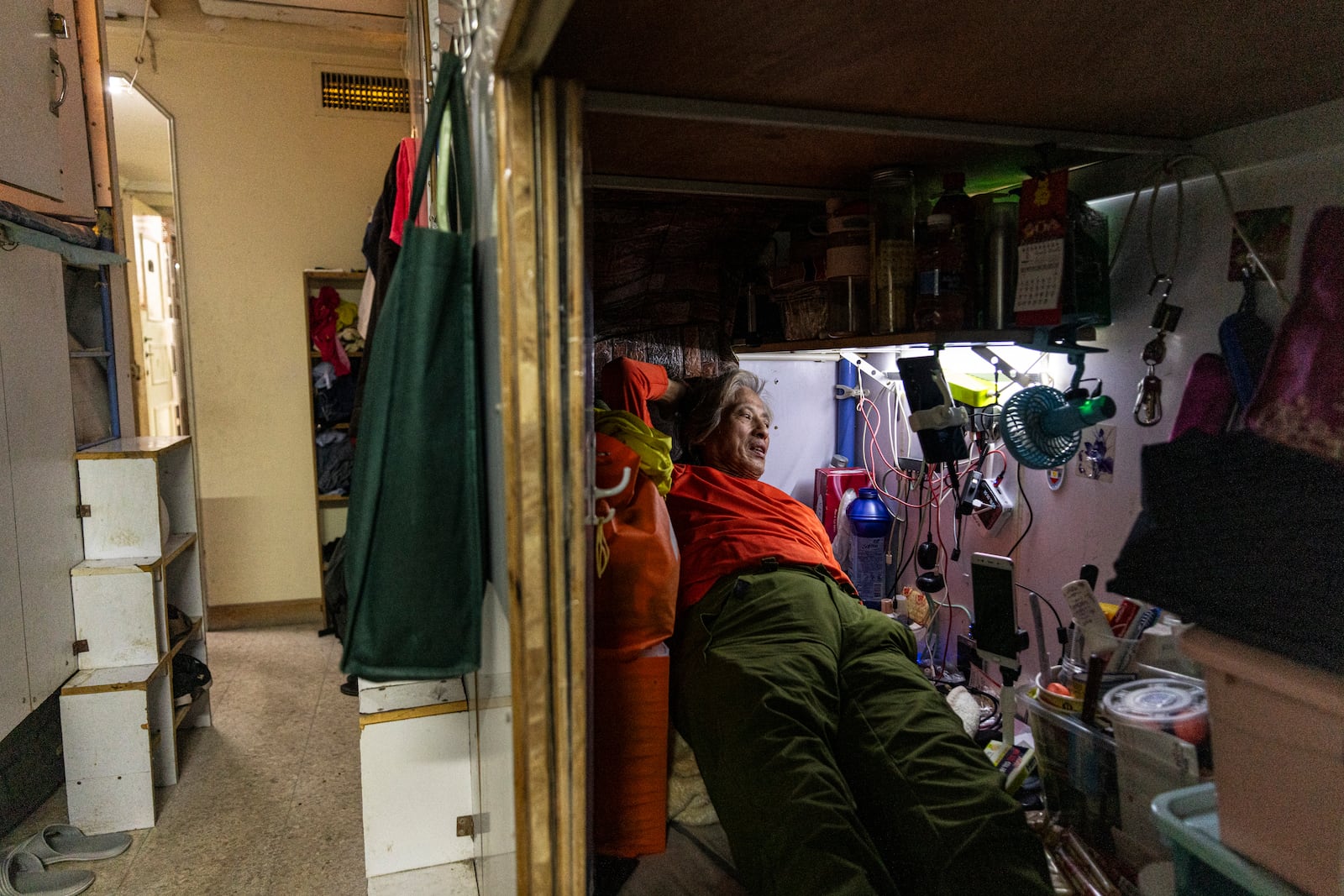 A resident rests in his bed space in Sham Shui Po district of Hong Kong, on Feb. 6, 2025. (AP Photo/Chan Long Hei)