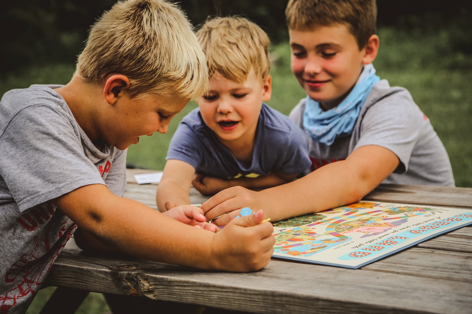 Lena White's three sons play a boardgame at a picnic table at Rye Camp. White, who runs the campground with her partner, is a former professional model as well as a Trauma-Informed Care Practitioner for NICU babies. CONTRIBUTED