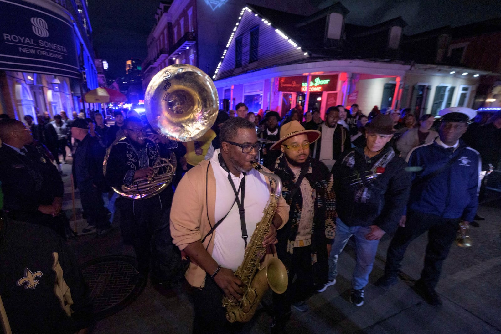 Tubad and the Kings of NOLA Brass Band plays in New Orleans, Saturday, Jan. 4, 2025, as they memorialize the victims of the New Year's Day deadly truck attack and shooting. Playing sousaphone is Timothy Brown, left, saxophone is Corey Hosey, Amir "Tubad" Gray, wearing hat, trumpet is Kenneth Hagans, far right, also with the parade is artist Roberto Marquez, second right, who organized the vigil and designed a memorial for the victims on Bourbon Street. (AP Photo/Matthew Hinton)