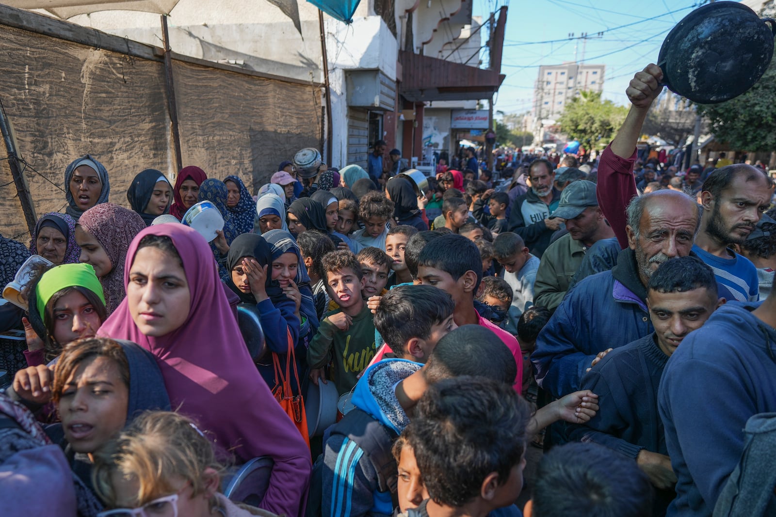 Palestinians queue for food in Deir al-Balah, Gaza Strip, Monday, Nov. 18, 2024. (AP Photo/Abdel Kareem Hana)