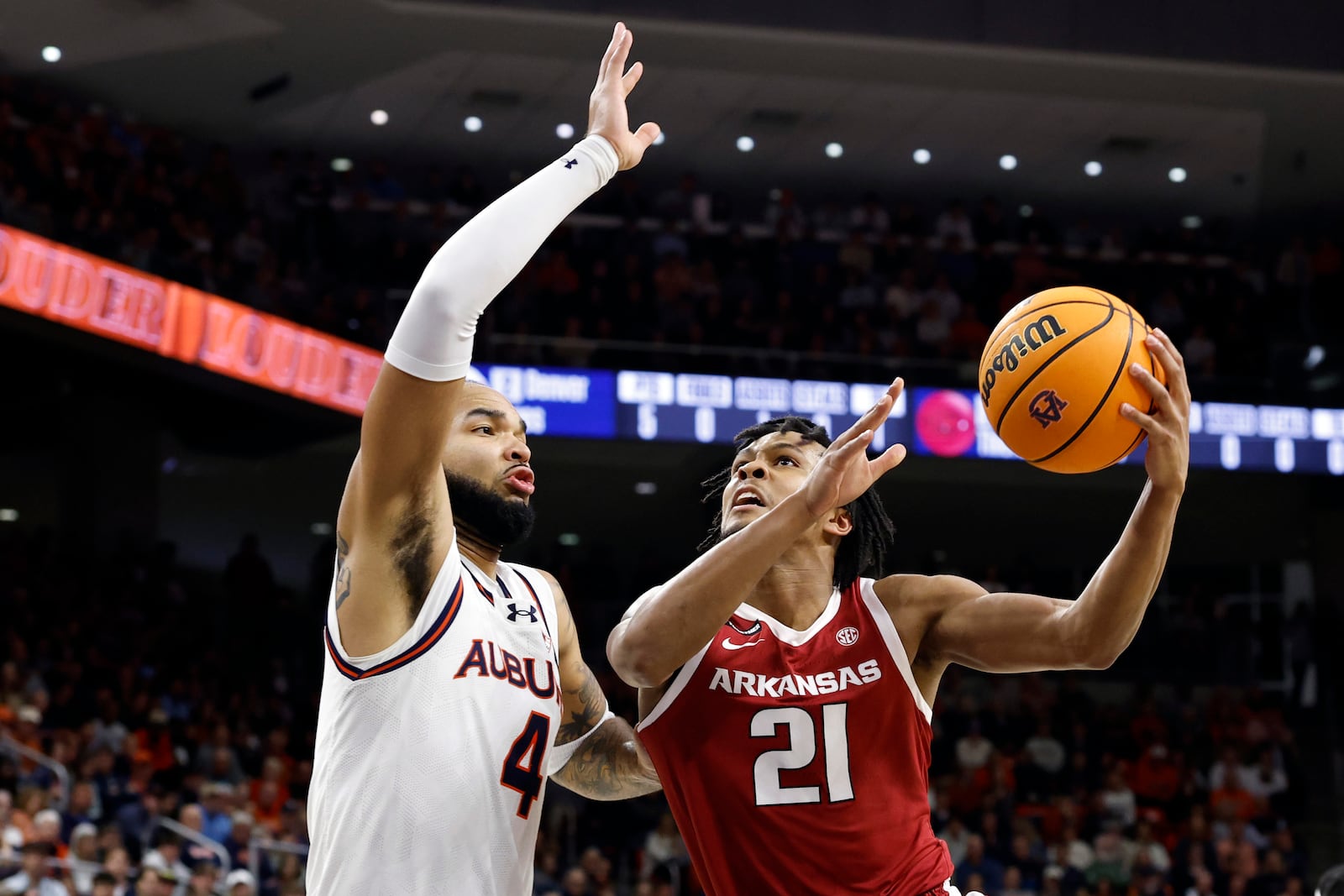 Arkansas guard D.J. Wagner (21) goes up for a shot around Auburn forward Johni Broome (4) during the first half of an NCAA college basketball game, Wednesday, Feb. 19, 2025, in Auburn, Ala. (AP Photo/Butch Dill)