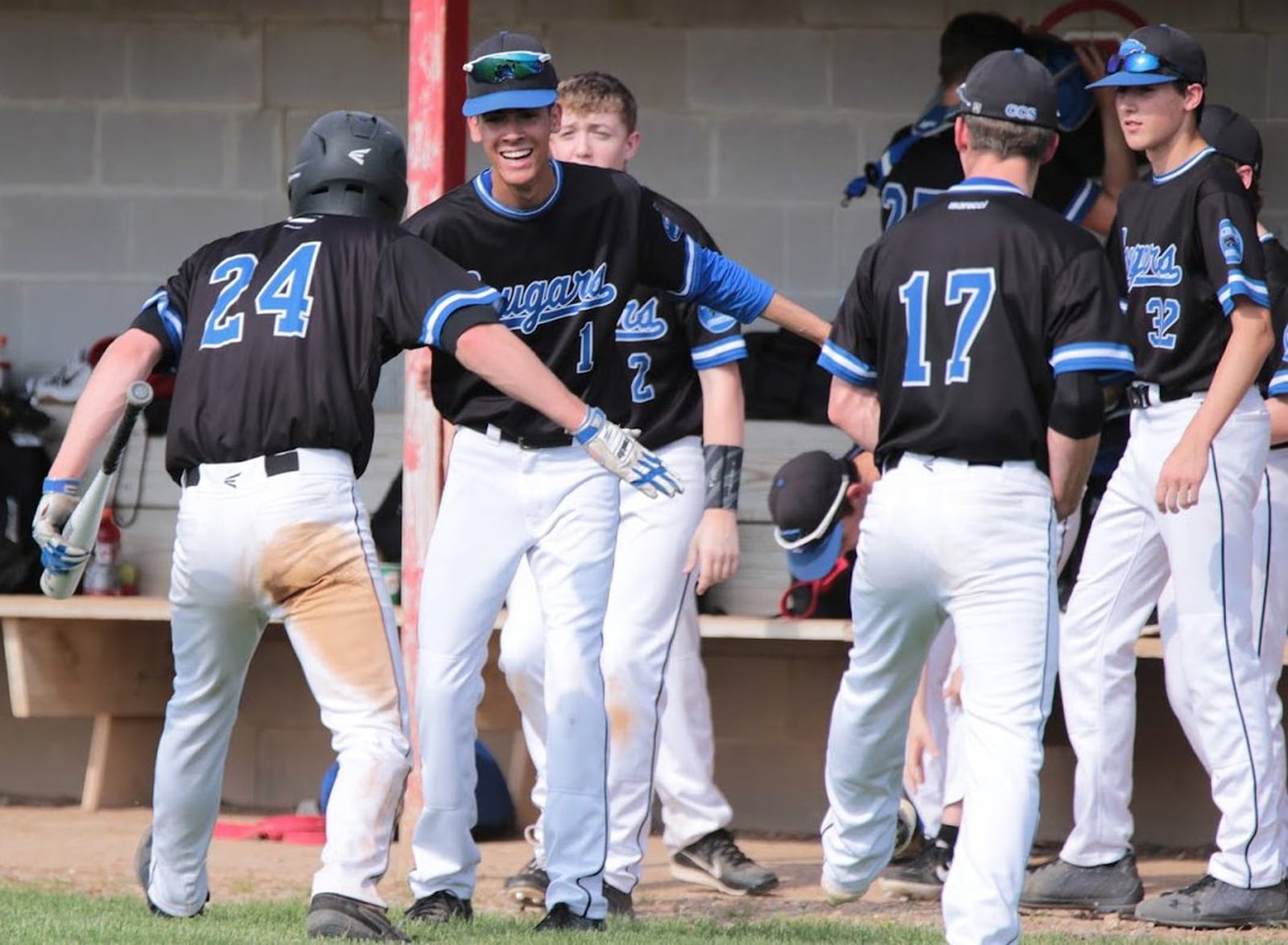 Cincinnati Christian’s Mitchell Smith (24) is congratulated by teammate Winston Spencer (1) after scoring a run Friday during a Division IV district baseball final against Tri-County North at Carlisle. CCS won 3-1. PHOTO BY KRAE/WWW.KRAEPHOTOGRAPHY.COM