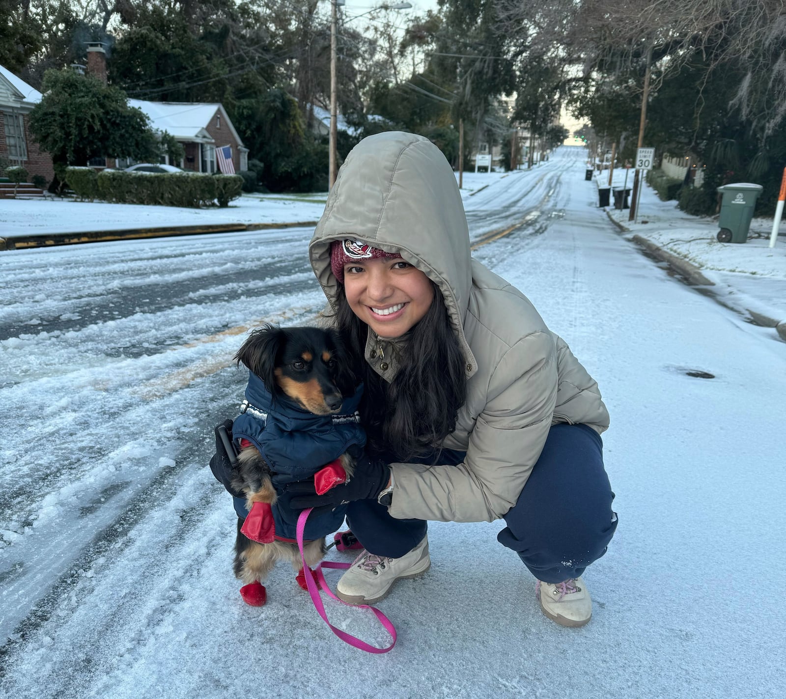 Lina Rojas prepares her dachshund Petunia with a warm vest and gloves for her first walk in snow, in Tallahassee, Fla., Wednesday, Jan. 22, 2025. (AP Photo/Kate Payne)