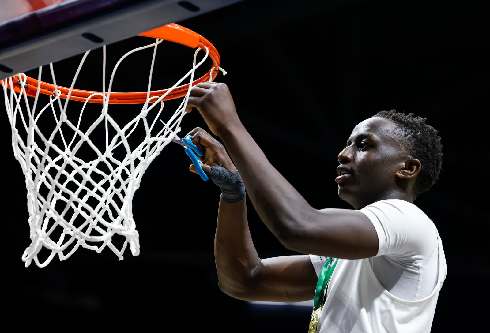 Centerville's Emmanuel Deng cuts down the net after their Division I regional final basketball game against Fairfield Saturday, March 11, 2023 at Xavier University's Cintas Center. Centerville won 64-53. NICK GRAHAM/STAFF