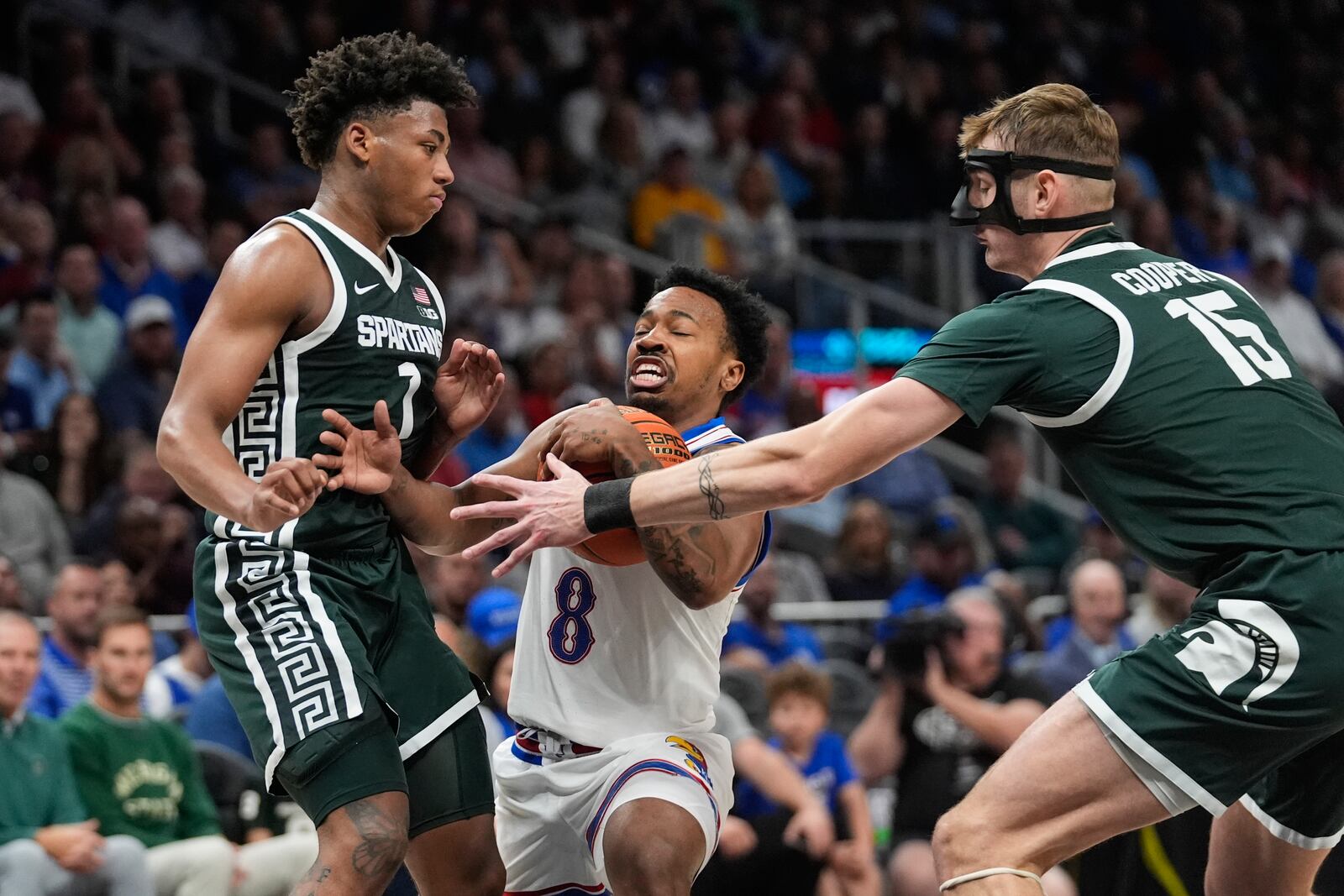 Kansas guard David Coit (8) tries to go between Michigan State's Jaden Akins (3) and Carson Cooper (15) during the first half of an NCAA college basketball game, Tuesday, Nov. 12, 2024, in Atlanta. (AP Photo/John Bazemore )