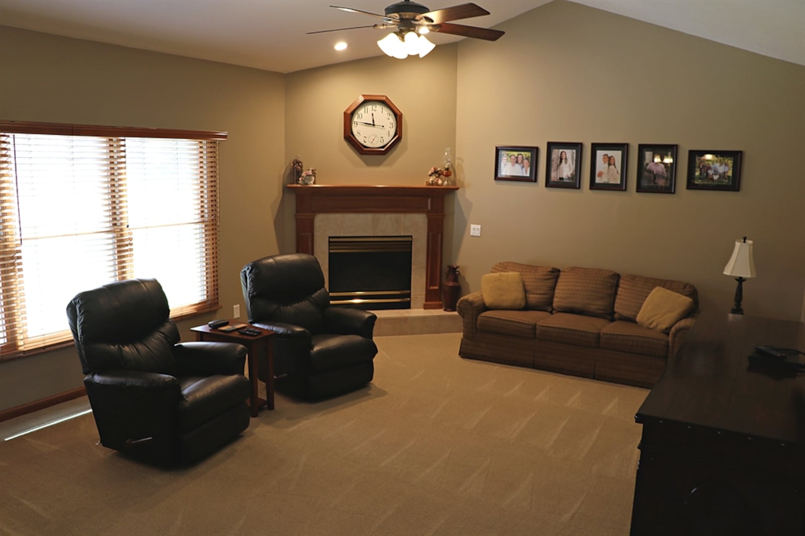 In the family room, windows along one wall allow for natural light. Tucked into a corner is a gas fireplace. 