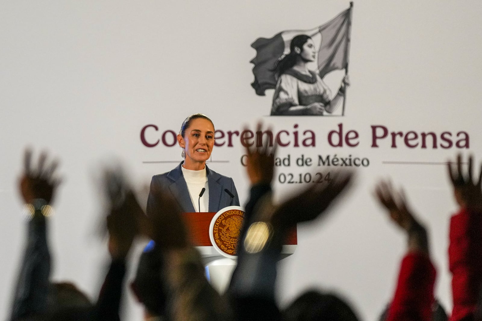 FILE - Mexican President Claudia Sheinbaum gives a media briefing as journalists raise their hands to ask questions, at the National Palace in Mexico City, Oct. 2, 2024. (AP Photo/Fernando Llano, File)