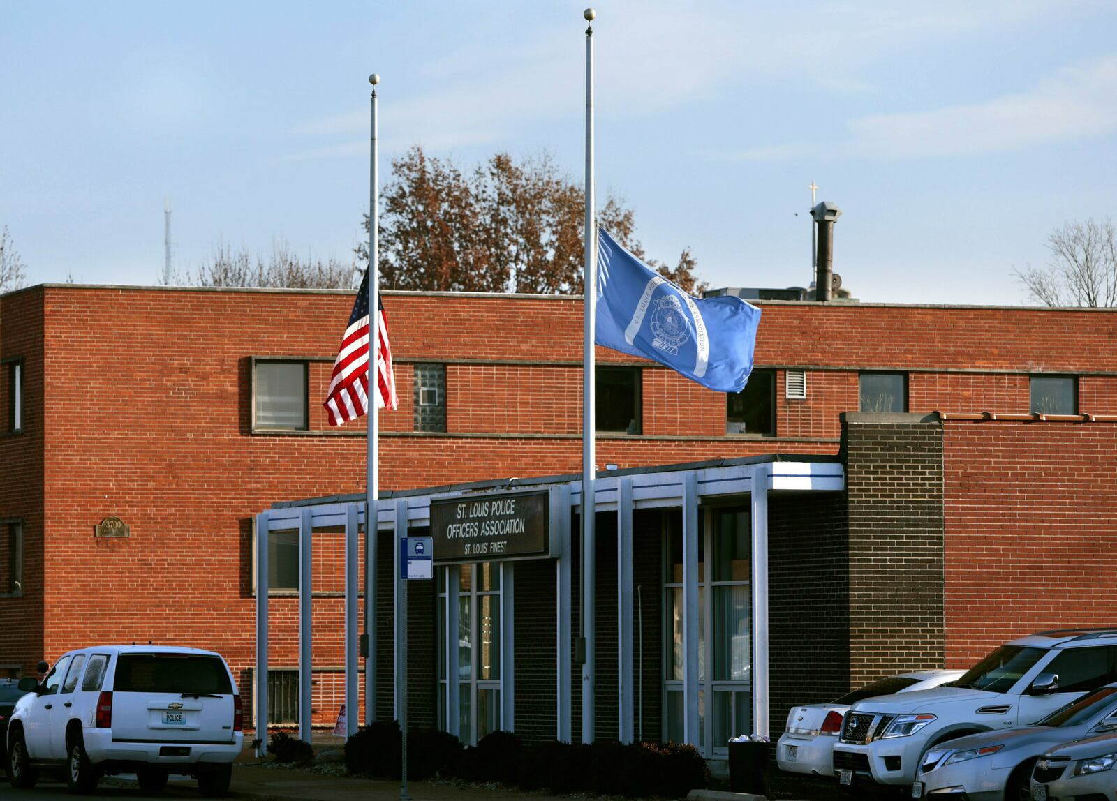 Flags fly at half-staff in front of the St. Louis Police Officers Association on Thursday, Jan. 24, 2019, following the shooting death of 24-year-old Officer Katlyn Alix. Alix, an Army veteran, was fatally shot in the chest by a colleague, Officer Nathaniel Hendren, 29, as the pair played Russian roulette, court documents allege.