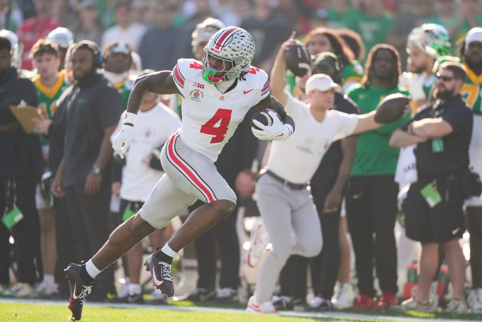 Ohio State wide receiver Jeremiah Smith (4) runs the ball for a touchdown after a catch during the first half in the quarterfinals of the Rose Bowl College Football Playoff against Oregon, Wednesday, Jan. 1, 2025, in Pasadena, Calif. (AP Photo/Mark J. Terrill)