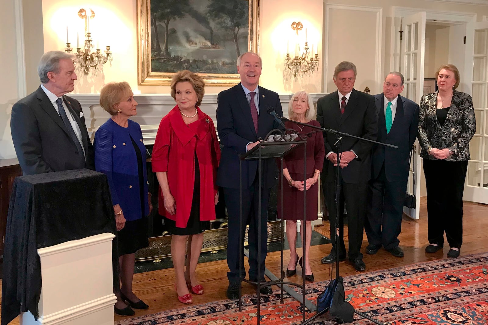 FILE - Former Gov. Jim Guy Tucker, left, joins Arkansas Gov. Asa Hutchinson, center, and fellow former governors to celebrate the 70th anniversary of the state's Governor's Mansion, at the residence in Little Rock, Ark., Feb. 3, 2020. (AP Photo Andrew DeMillo, File)