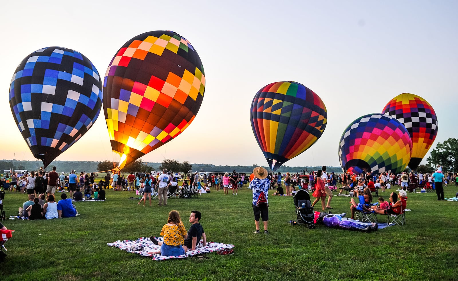 Balloon enthusiasts gather for the balloon glow during The Ohio Challenge hot air balloon festival Friday, July 19, 2019 at Smith Park in Middletown.  NICK GRAHAM/STAFF