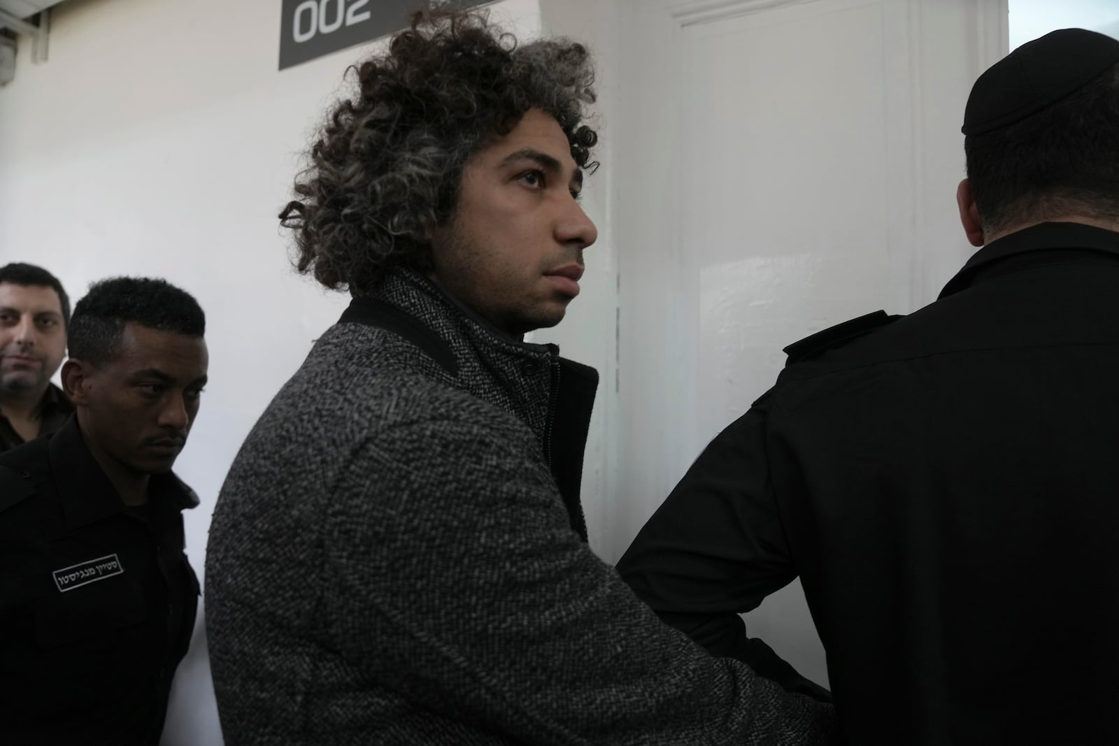 Booksellers Ahmad, left, and Mahmoud Muna are led into court after their arrest during an Israeli police have raid of their long-established Palestinian-owned Educational Bookshop in east Jerusalem, Monday, Feb. 10, 2025. (AP Photo/Mahmoud Illean)