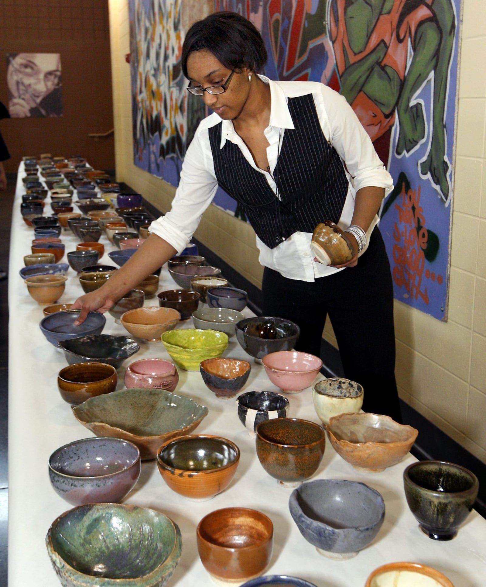 In this file photo, Karisma Carpenter then a 10th grade ceramics student at Stivers School for the Arts, arranges bowls for the school’s annual “Soup Dressed Up” fundraiser. Patrons choose from the tables of hand-made ceramic bowls and then dine on soup, bread, dessert and drink donated by local restaurants. (File photo)