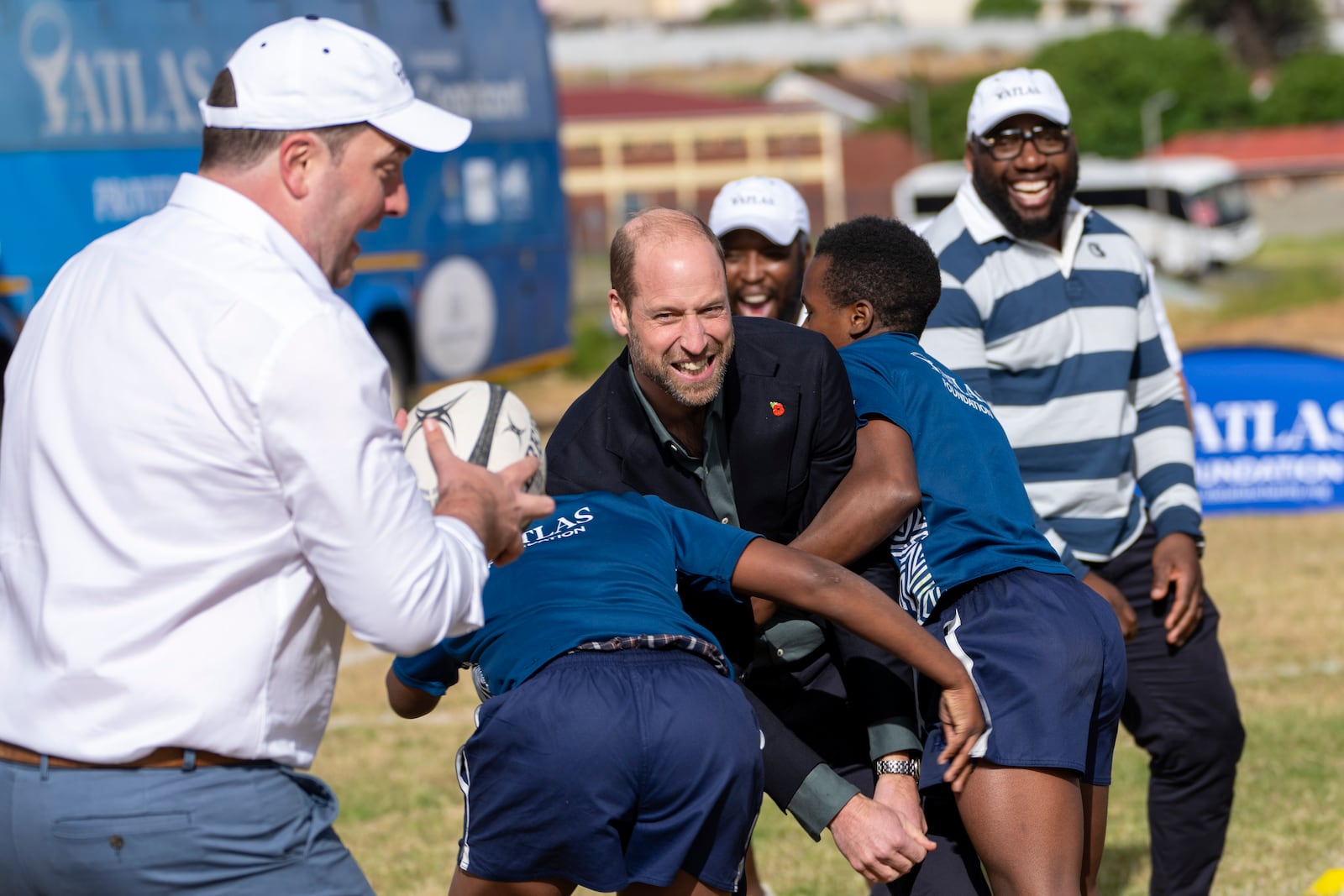 Britain's Prince William, is tackled playing rugby with pupils at the Ocean View Secondary School in Cape Town, South Africa, Monday, Nov. 4, 2024. (AP Photo/Jerome Delay-pool)