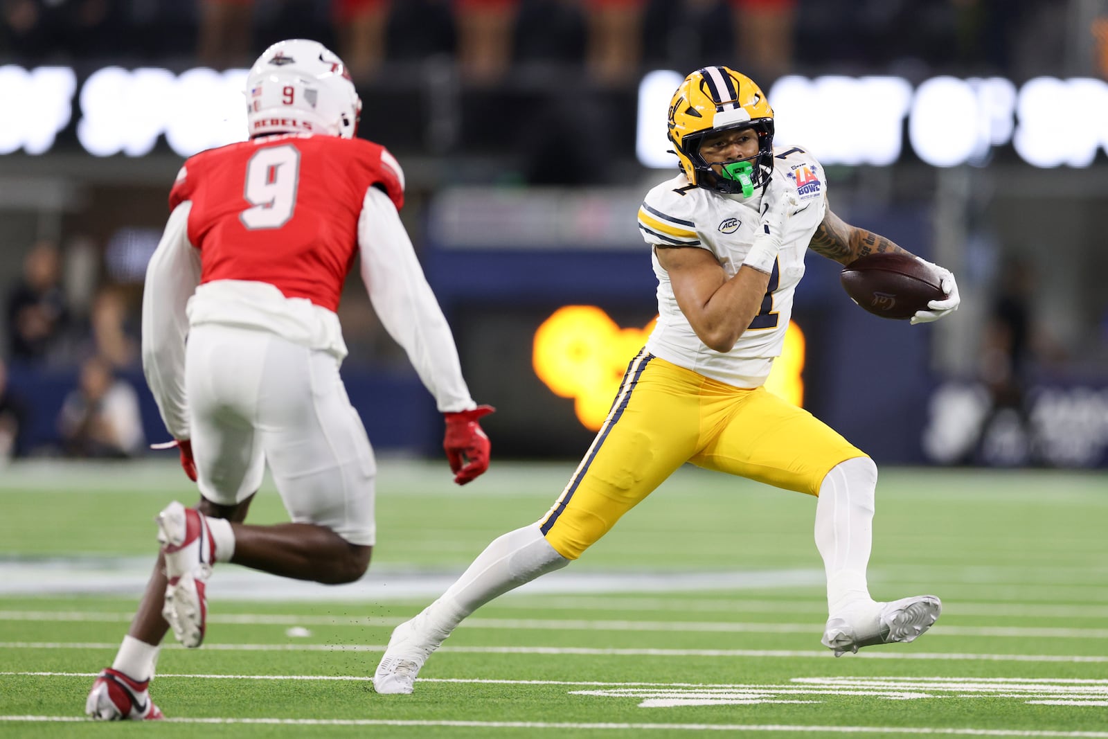 California running back Jaydn Ott, right, runs against UNLV defensive back Jett Elad during the first half of the LA Bowl NCAA college football game Wednesday, Dec. 18, 2024, in Inglewood, Calif. (AP Photo/Ryan Sun)